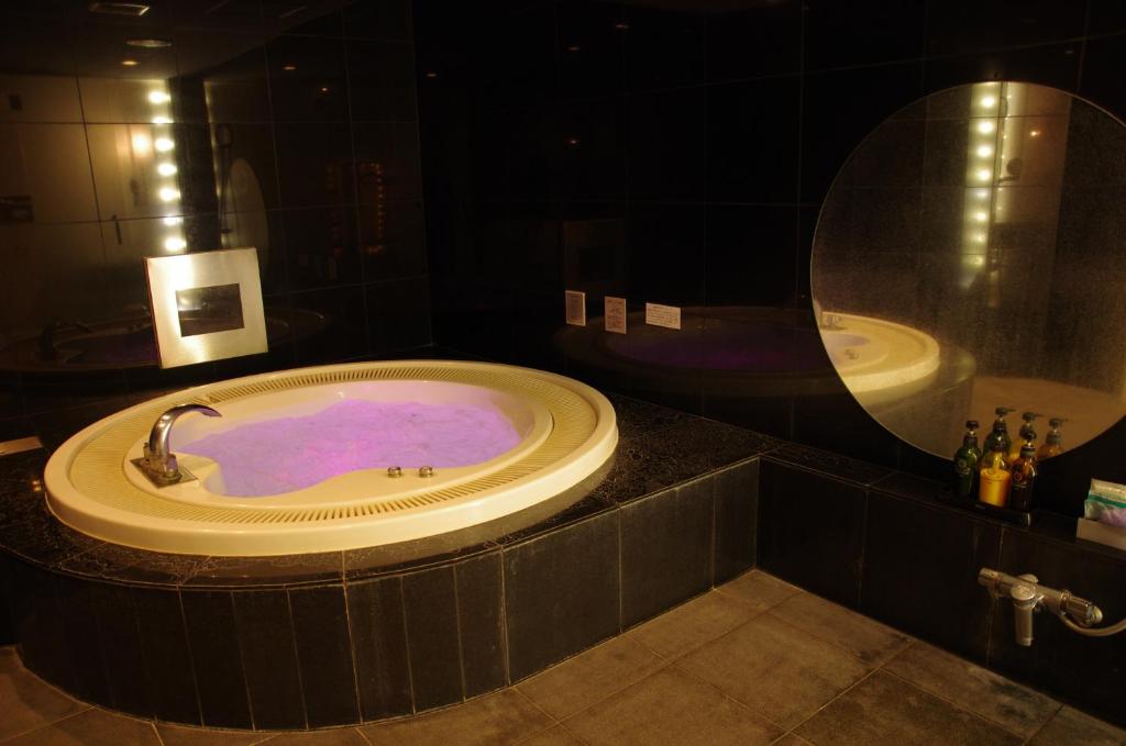 A hotel room with mood lighting and a hot tub with purple lights. This is available in Blue Hotel Octa in Sapporo, Japan.