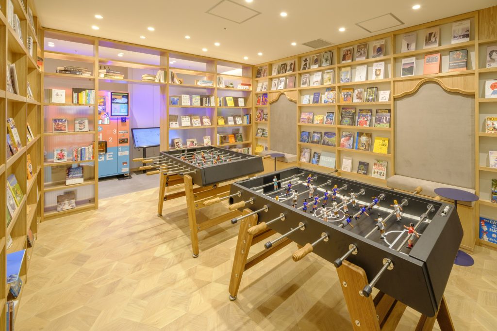 A cozy lounge room at Tosei Hotel COCONE Tsukiji featuring table games, a collection of vinyl records, and books for guests to enjoy.