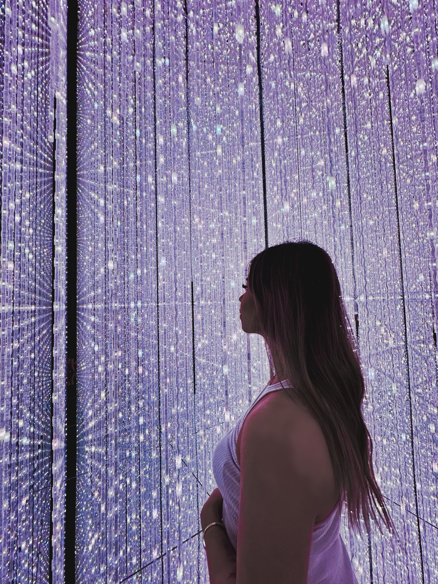 A girl standing in a room of light inside of TeamLab Planets, an art exhibit in Tokyo, Japan