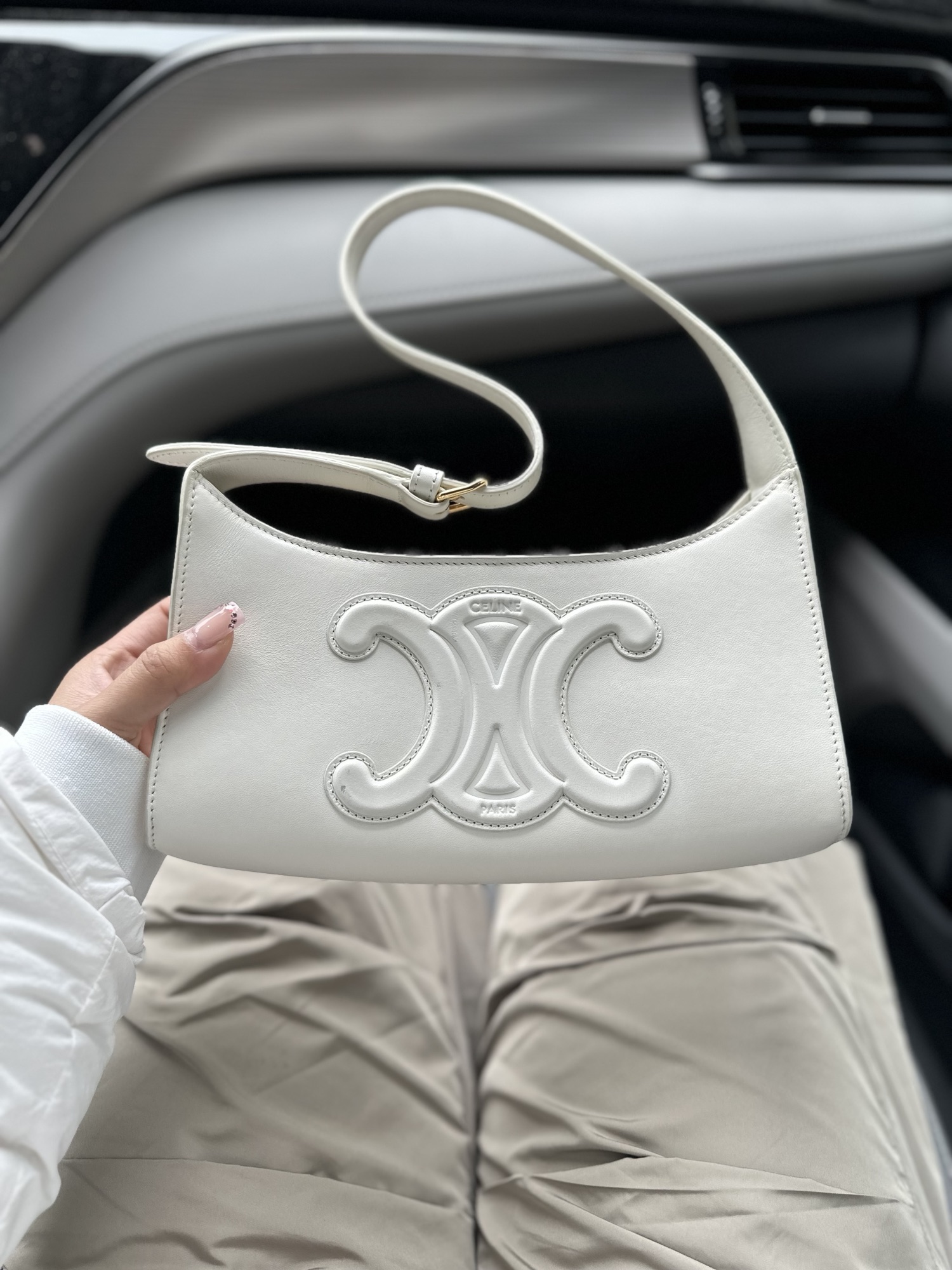 A white Celine shoulder bag with the Celine symbol on the front.