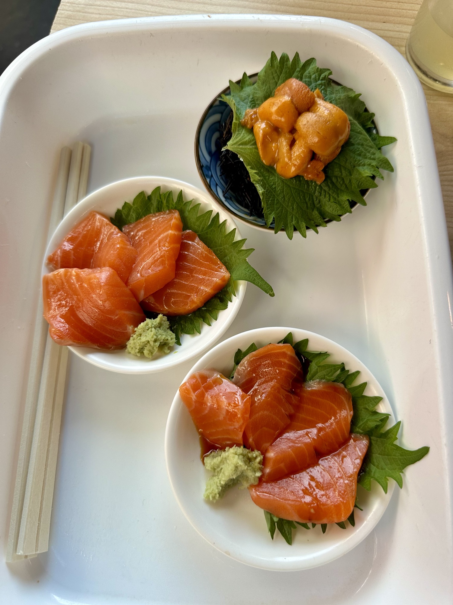 Two small bowls of salmon sashimi and uni from Tsukiji Fish Market in Tokyo, Japan.