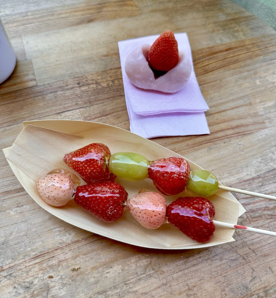 Tanghulu, a dessert consisting of fresh fruit with a hardened sugar coating, along with a sweet mochi daifuku with a strawberry and red bean filling.