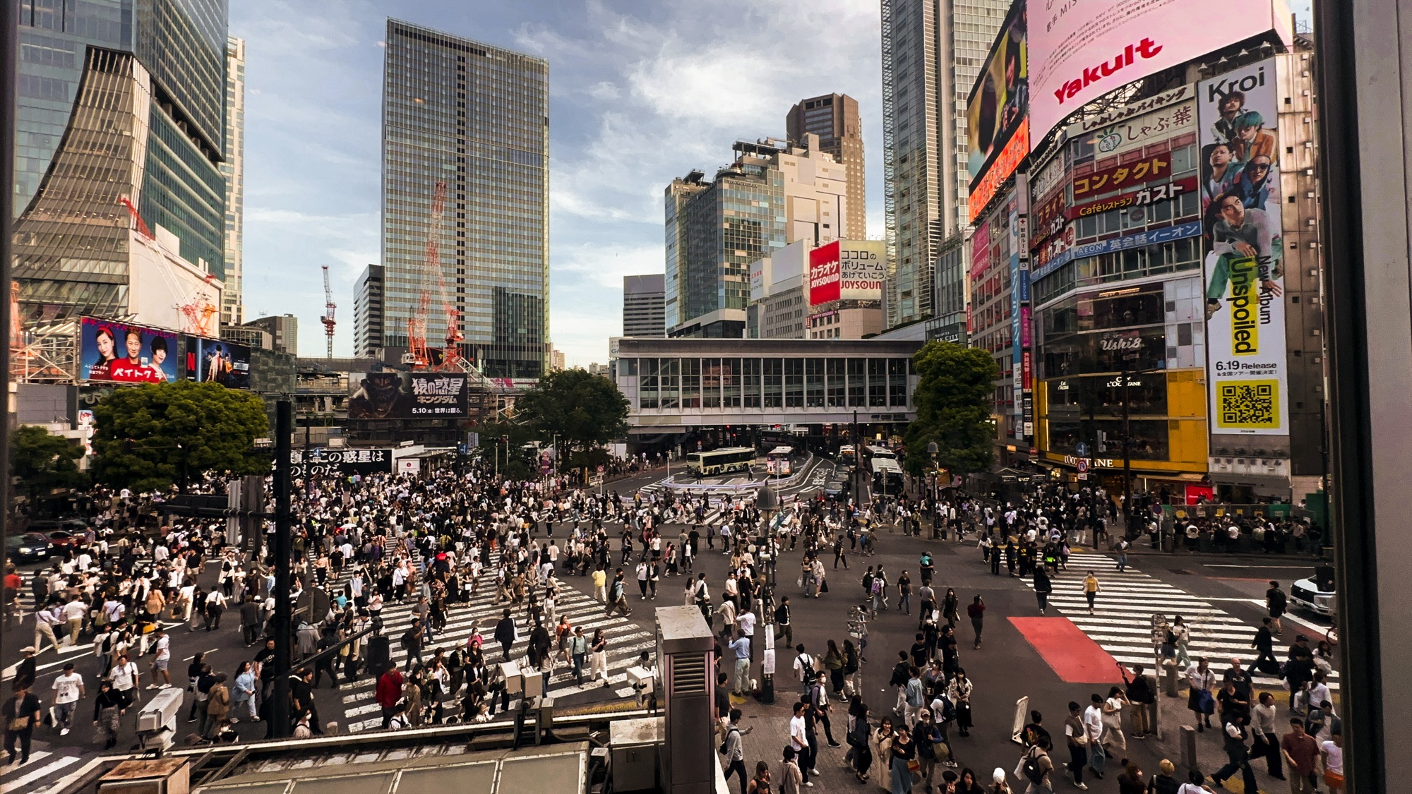 The view of the famous Shibuya Scramble Crossing from the Starbucks in Shibuya, Tokyo. Many people are crossing during the daytime.