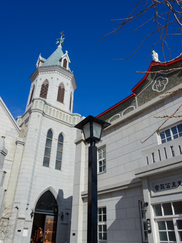 The Catholic Church in Motomachi, Hakodate. There are several buildings inspired by foreign cultures, symbolizing how Hakodate was one of the first ports to welcome foreign trade. The church is a white building with a light teal roof.
