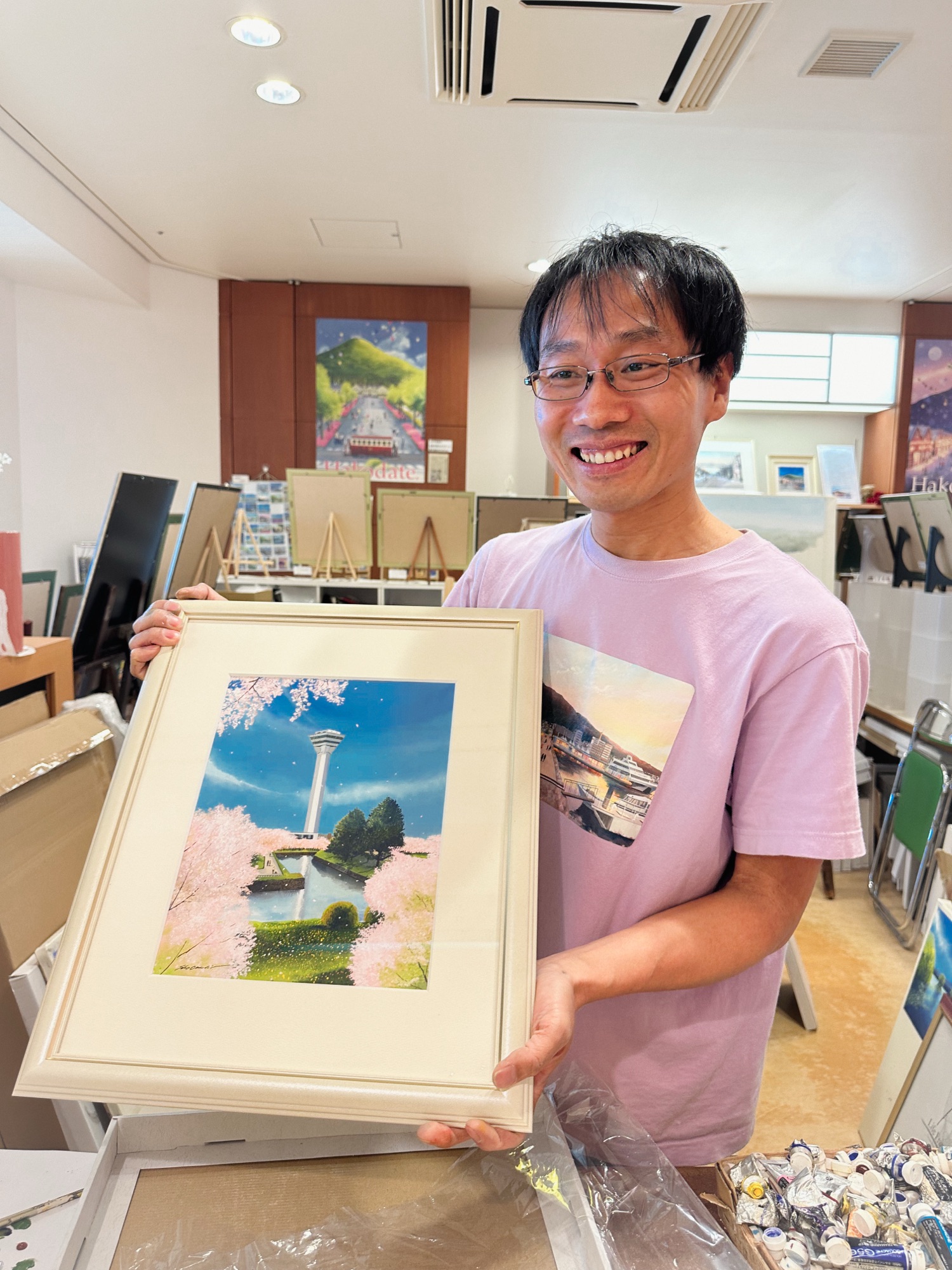Local artist Sho Onishi with his painting of Goryokaku Tower in Hakodate Airport.