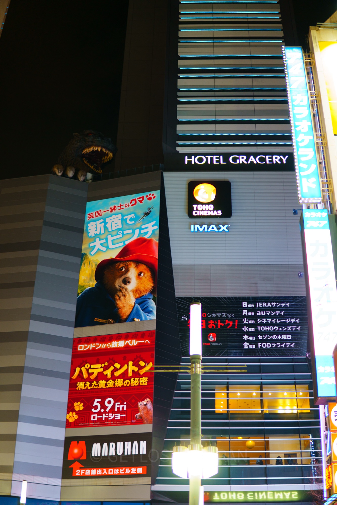 The Godzilla Head in Shinjuku, peering over Hotel Gracery Shinjuk at night.