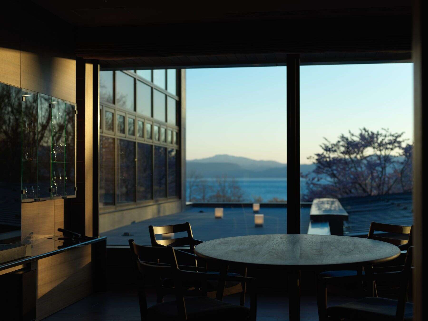 Elegant dining space with floor-to-ceiling windows and peaceful lake views at Ao no Za, capturing the tranquil luxury found in 5 star hotels in Sapporo’s surrounding nature.