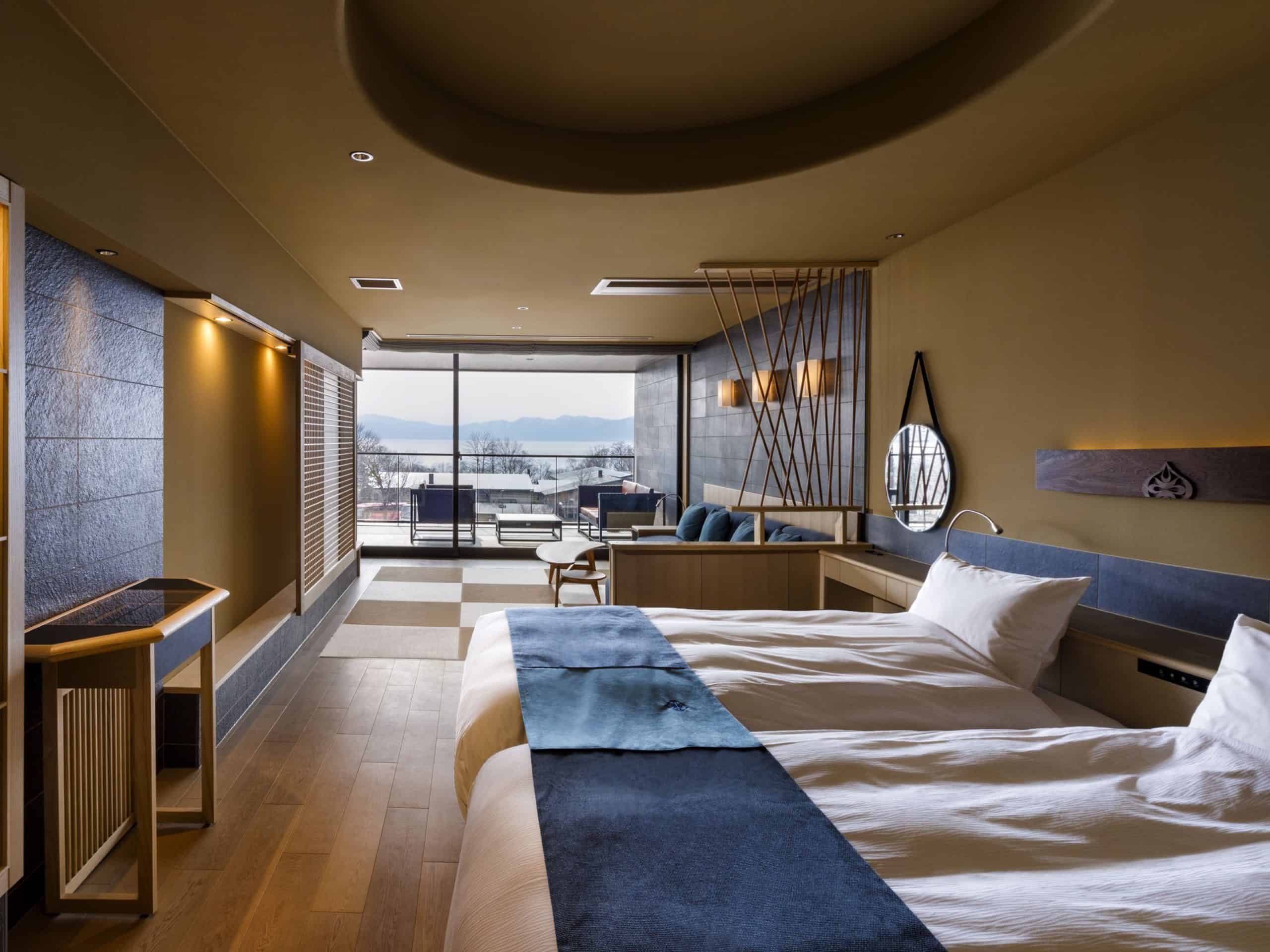 Spacious suite at Lake Shikotsu Tsuruga Besso Ao no Za, featuring twin beds, warm wood accents, and a private balcony with views—one of the most elegant 5 star hotels in Sapporo's lakeside region.