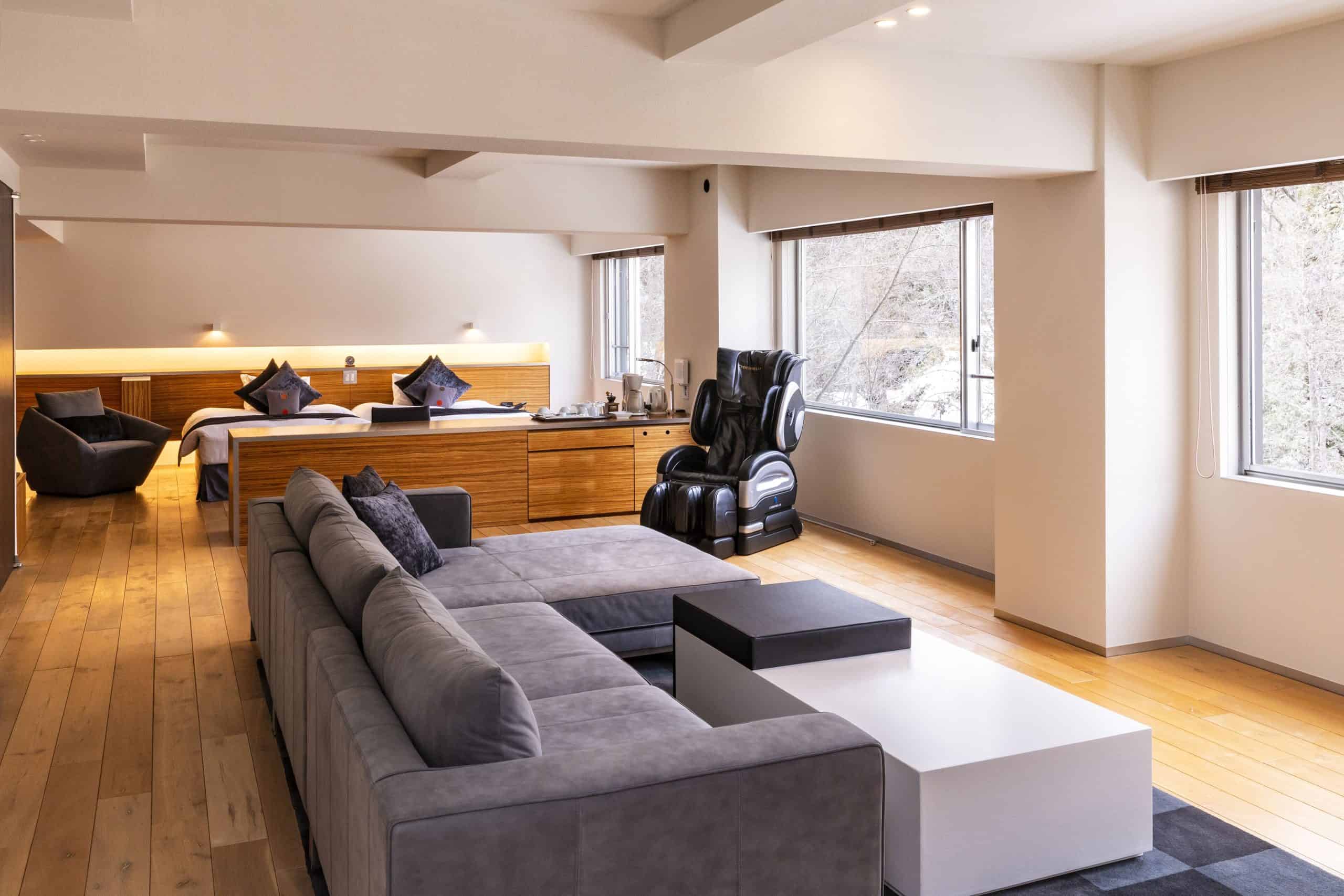 Spacious suite with a massage chair, plush sofa, and scenic windows at Bourou Noguchi Noboribetsu, a top contender among 5 star hotels near Sapporo.