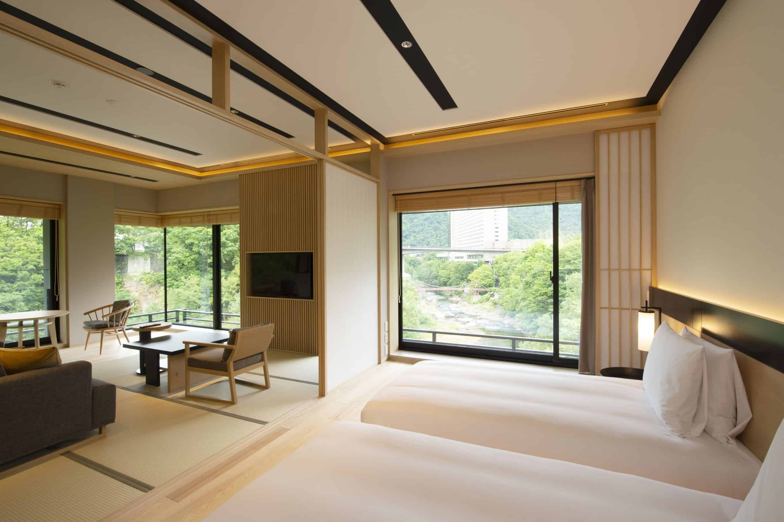 Elegant guest suite at Chalet Ivy Jozankei with twin beds, a traditional tatami area, and serene views of the Toyohira River and surrounding greenery.