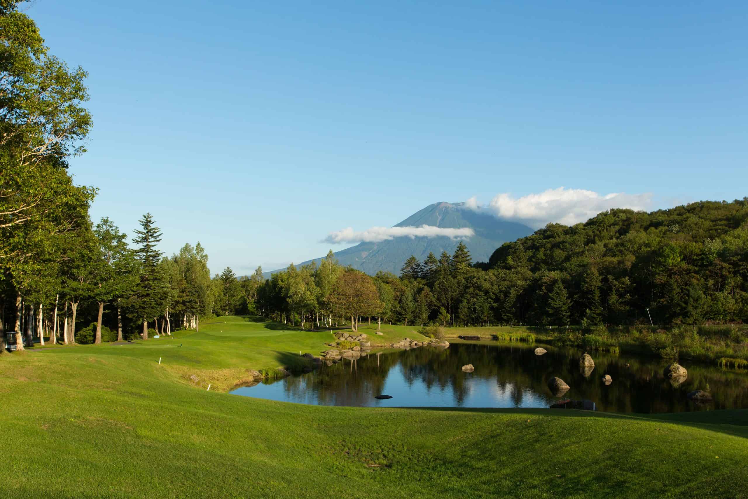 Lush green golf course surrounded by nature and a clear view of Mount Yotei, showcasing the scenic beauty near Park Hyatt Niseko Hanazono, one of the most scenic 5 star hotels in Sapporo’s greater region.