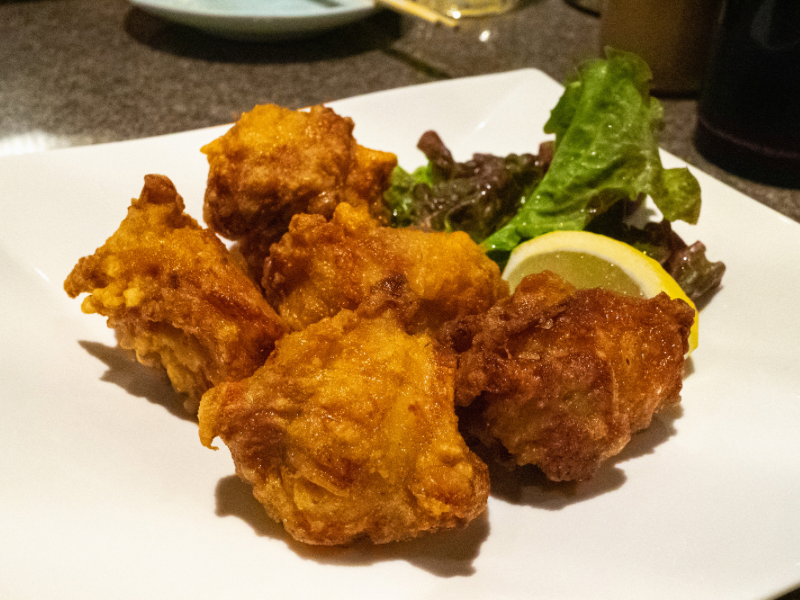 Crispy golden-brown pieces of Zangi, Hokkaido-style fried chicken, served with a wedge of lemon—one of the most iconic dishes and a must-try in Sapporo.