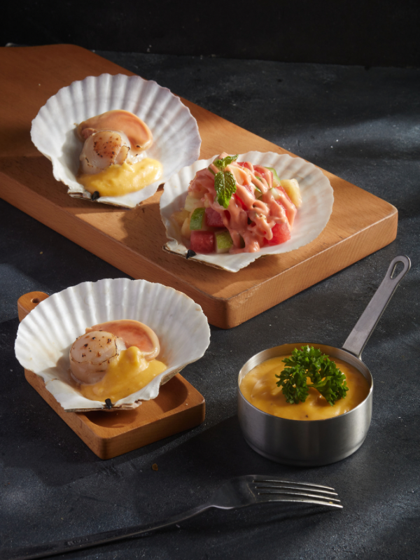 Seared scallops and fresh seafood served in shells with sauce—these local scallops are a must-try for anyone wondering what to eat in Sapporo.