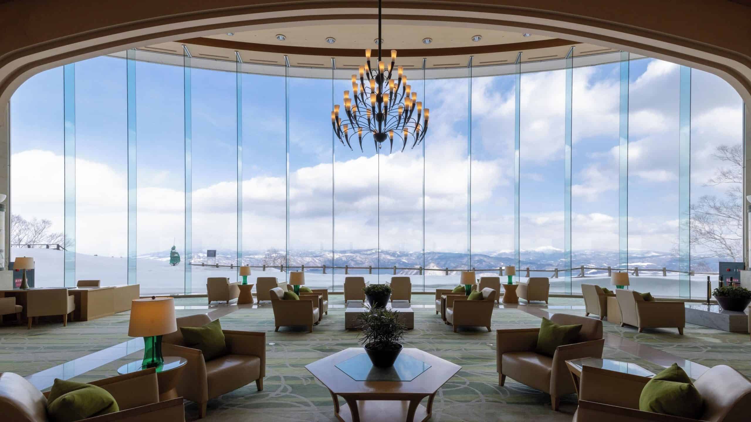 Spacious guest lounge at The Windsor Hotel Toya with dramatic glass walls overlooking snowy mountains and Lake Toya—a relaxing escape that elevates the standard for 5 star hotels in Sapporo.