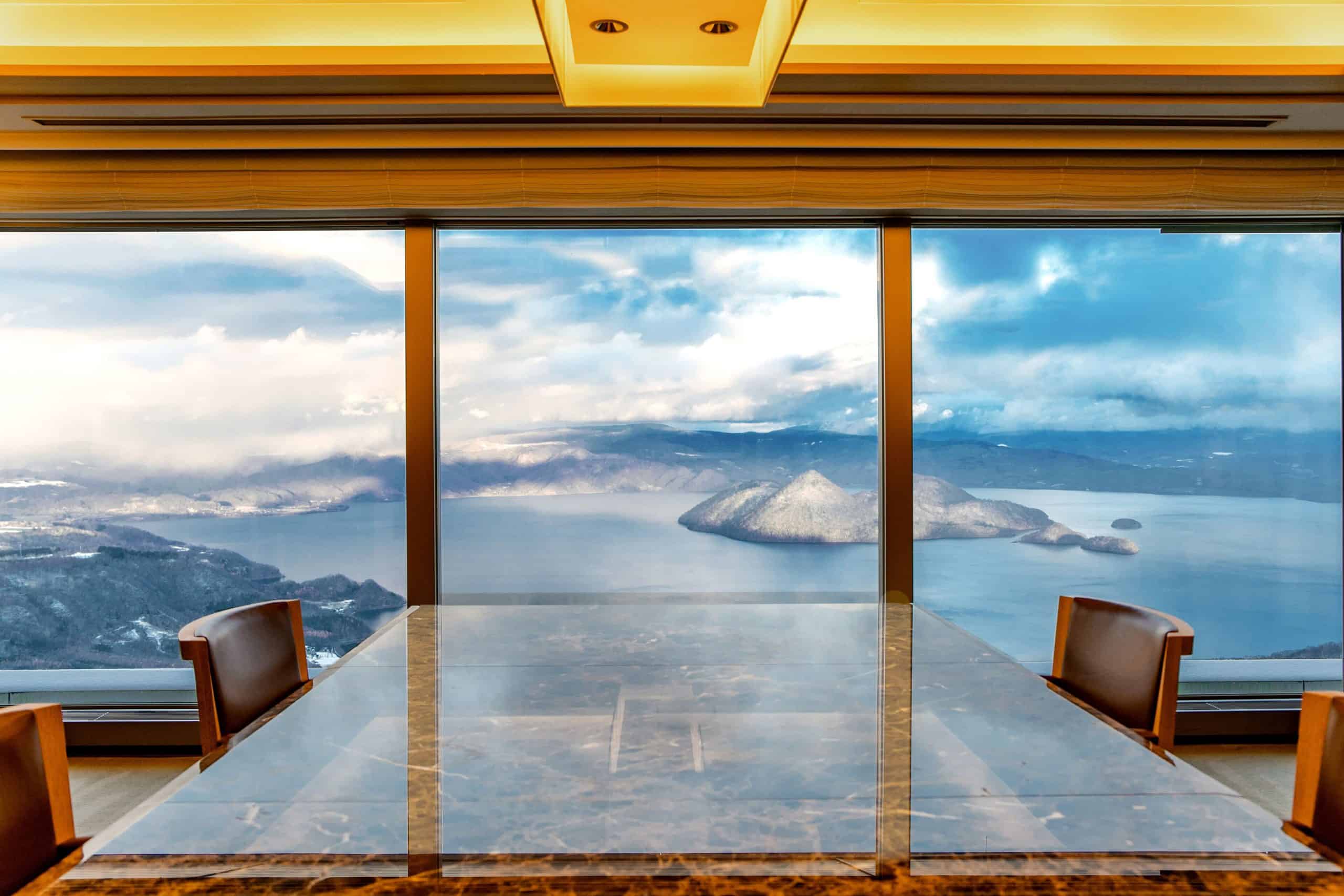 Elegant private dining setup with breathtaking views of Lake Toya, highlighting the upscale offerings of The Windsor Hotel Toya, one of the most scenic 5 star hotels in Sapporo’s vicinity.
