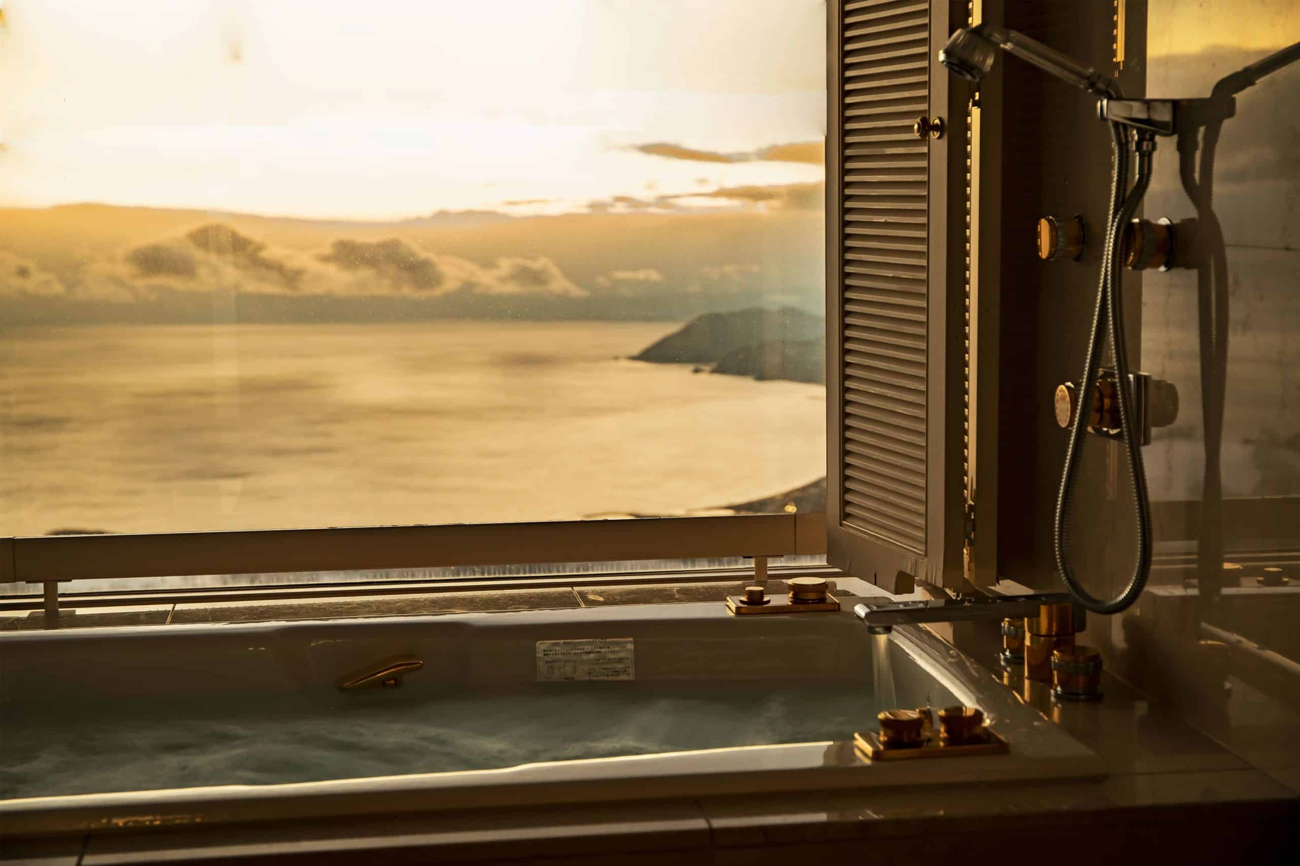 Luxury bath at The Windsor Hotel Toya overlooking the ocean at sunset—offering spa-like comfort and unmatched scenery at one of the top 5 star hotels in Sapporo’s surrounding region.