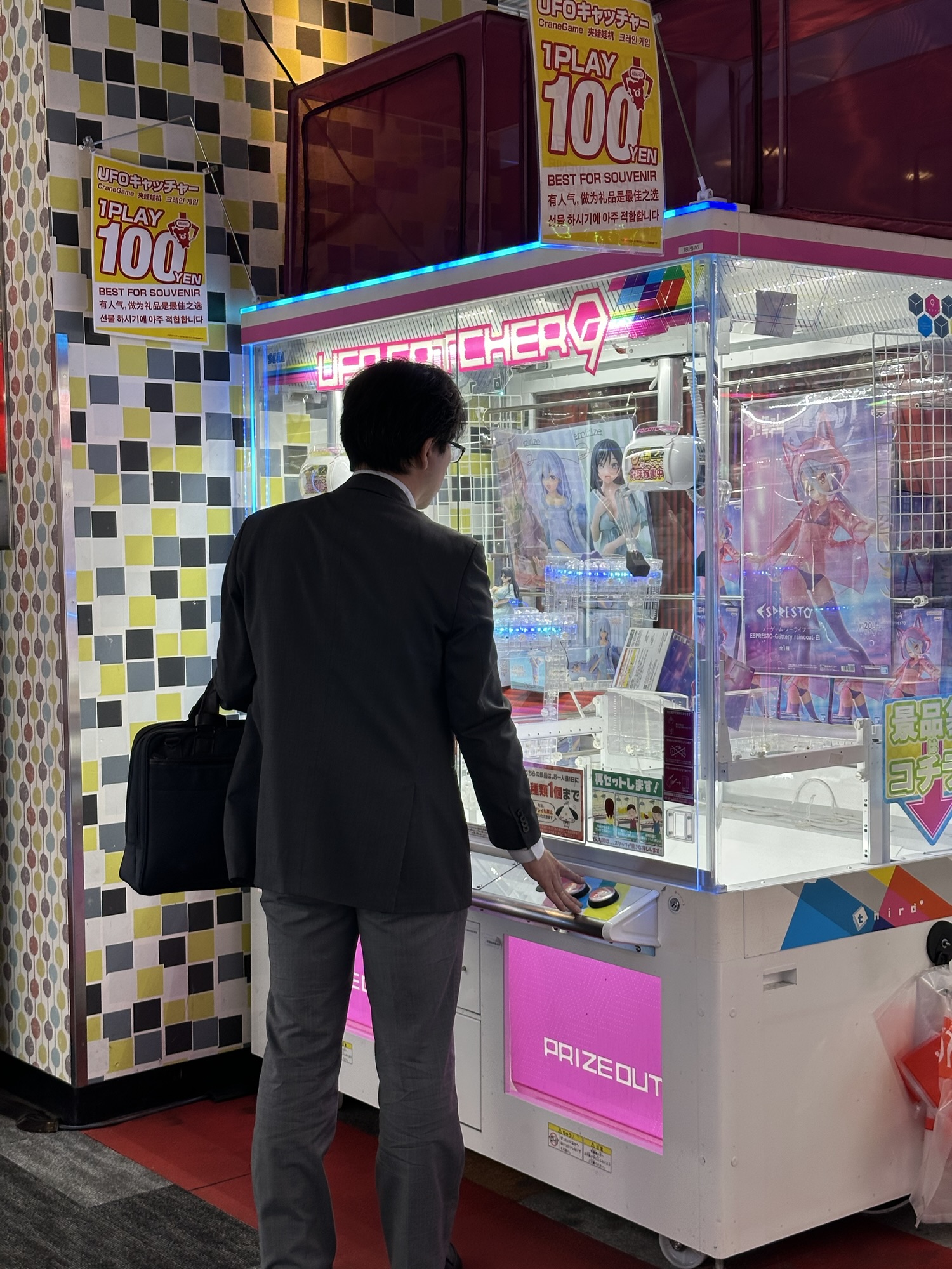 An asian salaryman playing on a crane machine in Round 1 in Japan