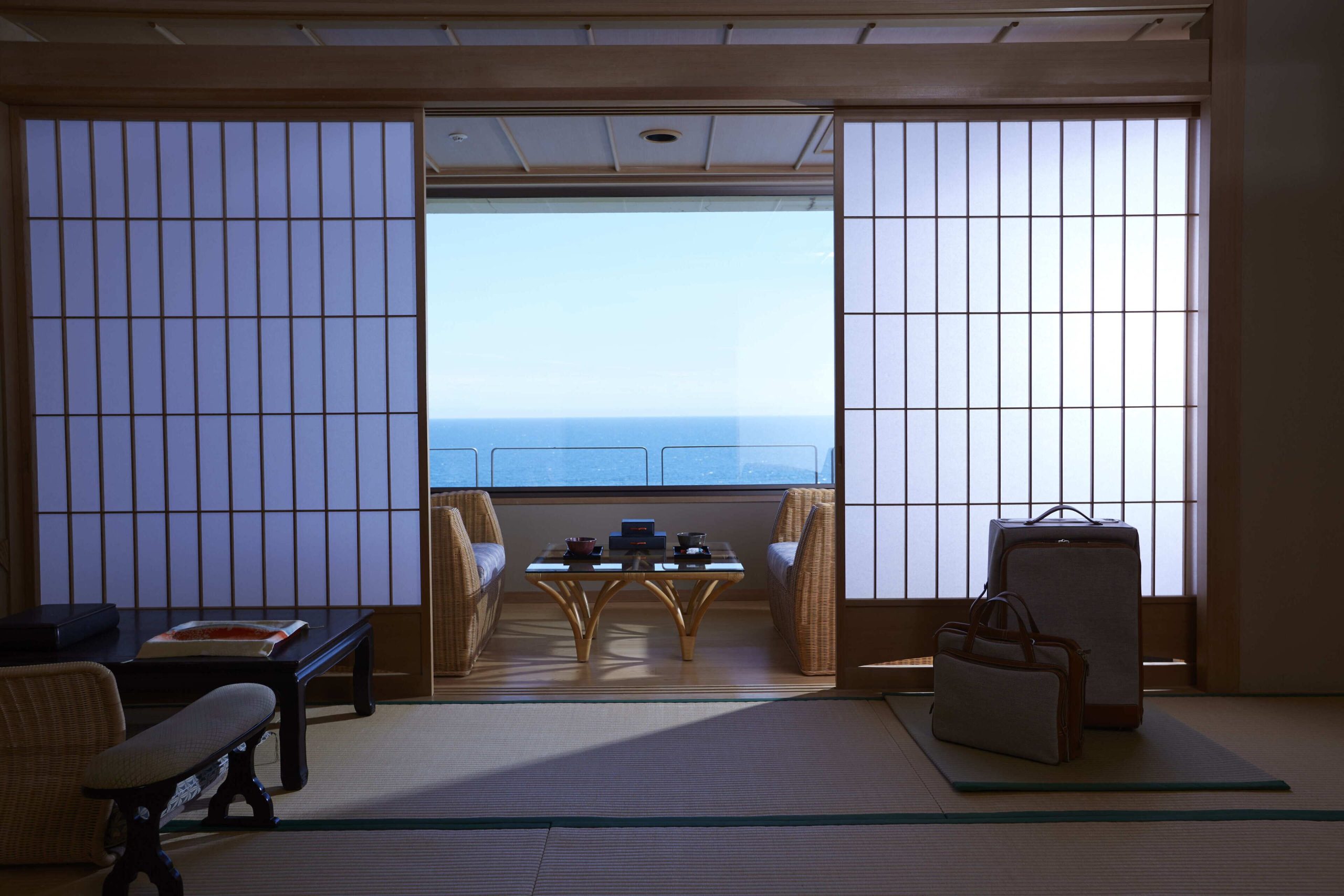 Traditional Japanese-style room at Wakamatsu Hot Spring Resort with sliding shoji doors and a stunning view of the ocean