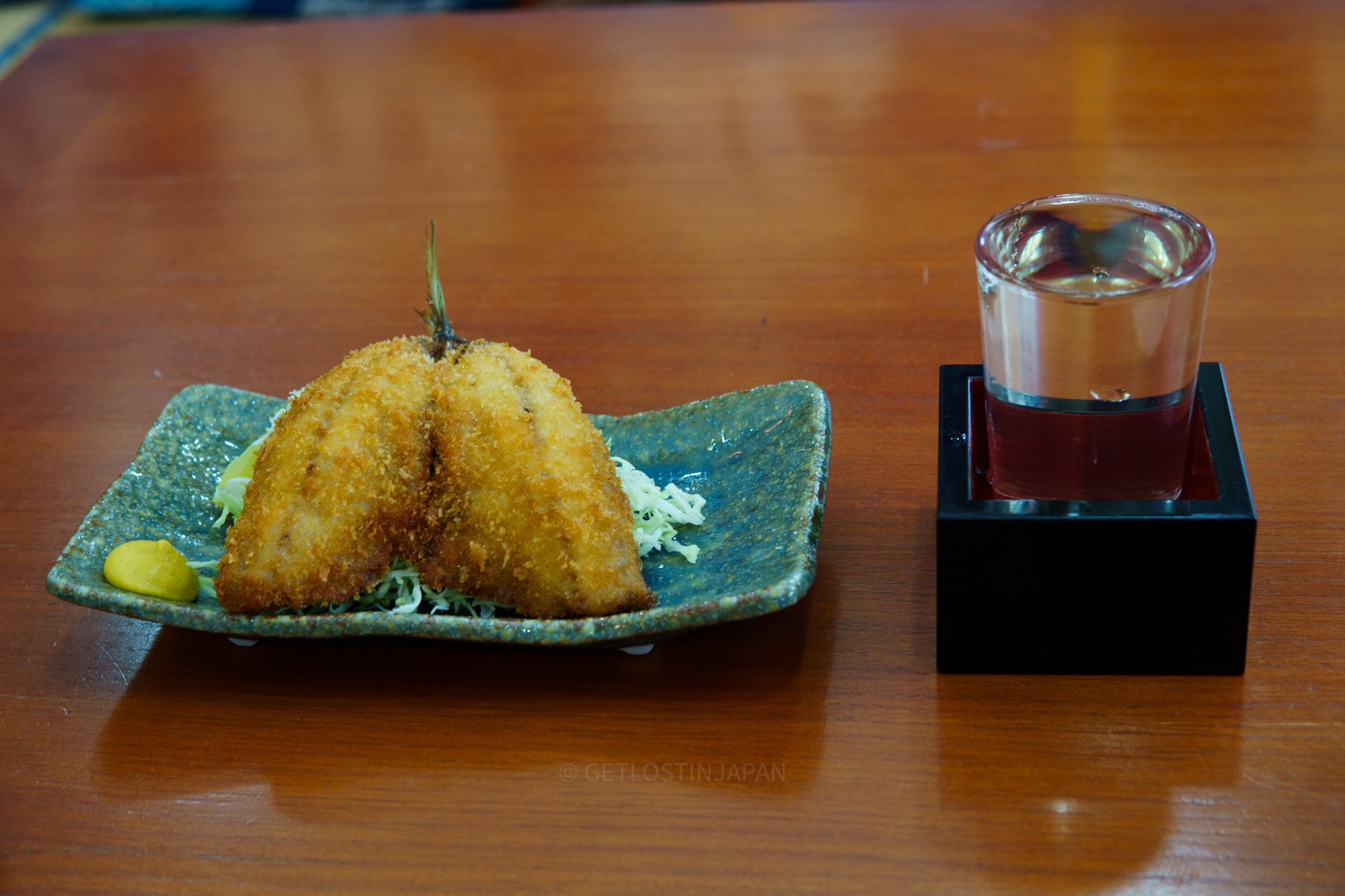 Fried horse mackerel paired with sake, a local specialty from Atami, a coastal seaside town near Tokyo.