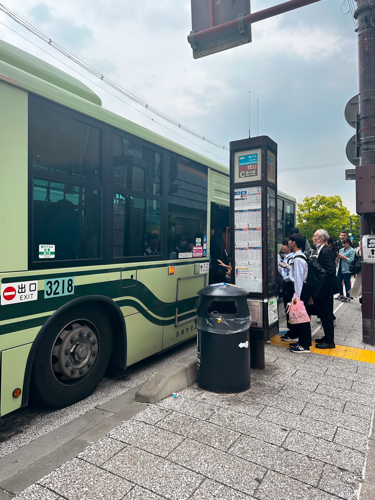 Bus stop going to Saka Hotel Kyoto with visitors boarding a Kyoto city bus, offering convenient public transportation
