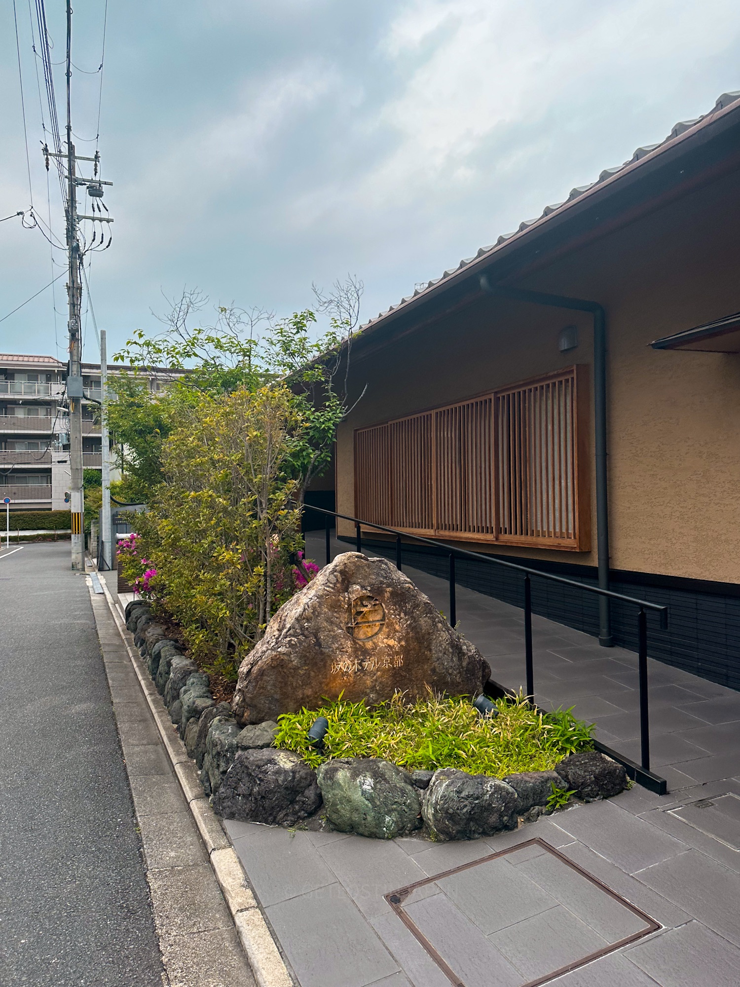 Entrance of Saka Hotel Kyoto with traditional architecture, stone signage, and a Japanese garden pathway