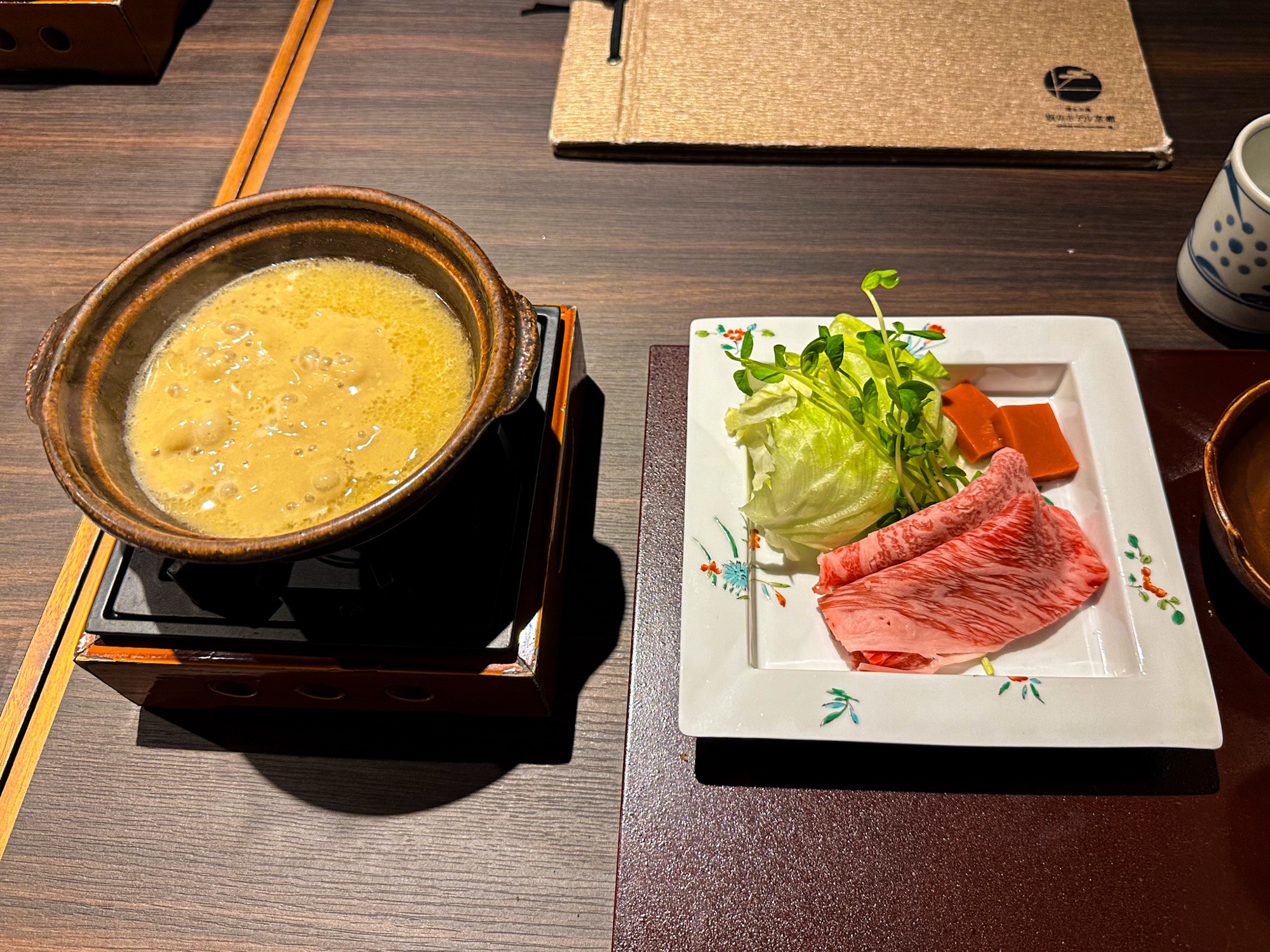 Traditional hot pot dinner setup at Saka Hotel Kyoto with marbled wagyu beef and vegetables