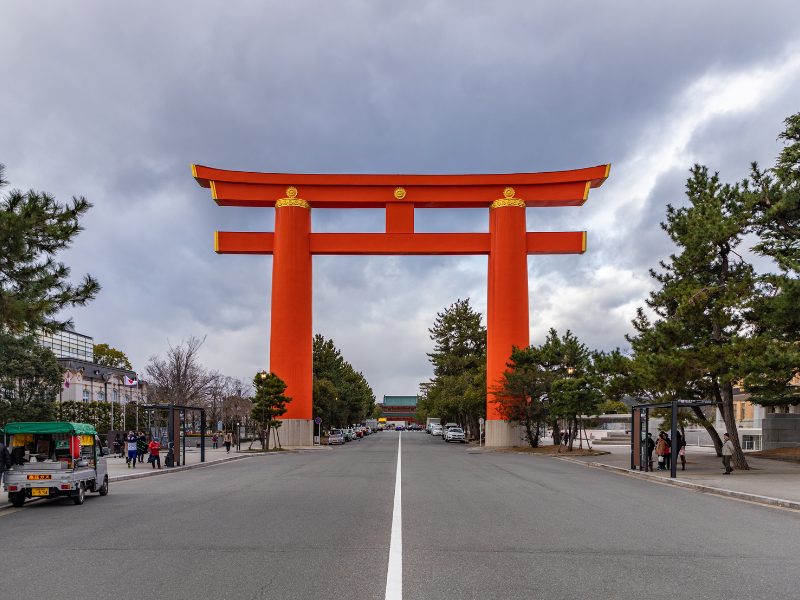 A massive bright red torii gate leading to Heian Shrine, one of the fun things to do in Kyoto for history and culture lovers.