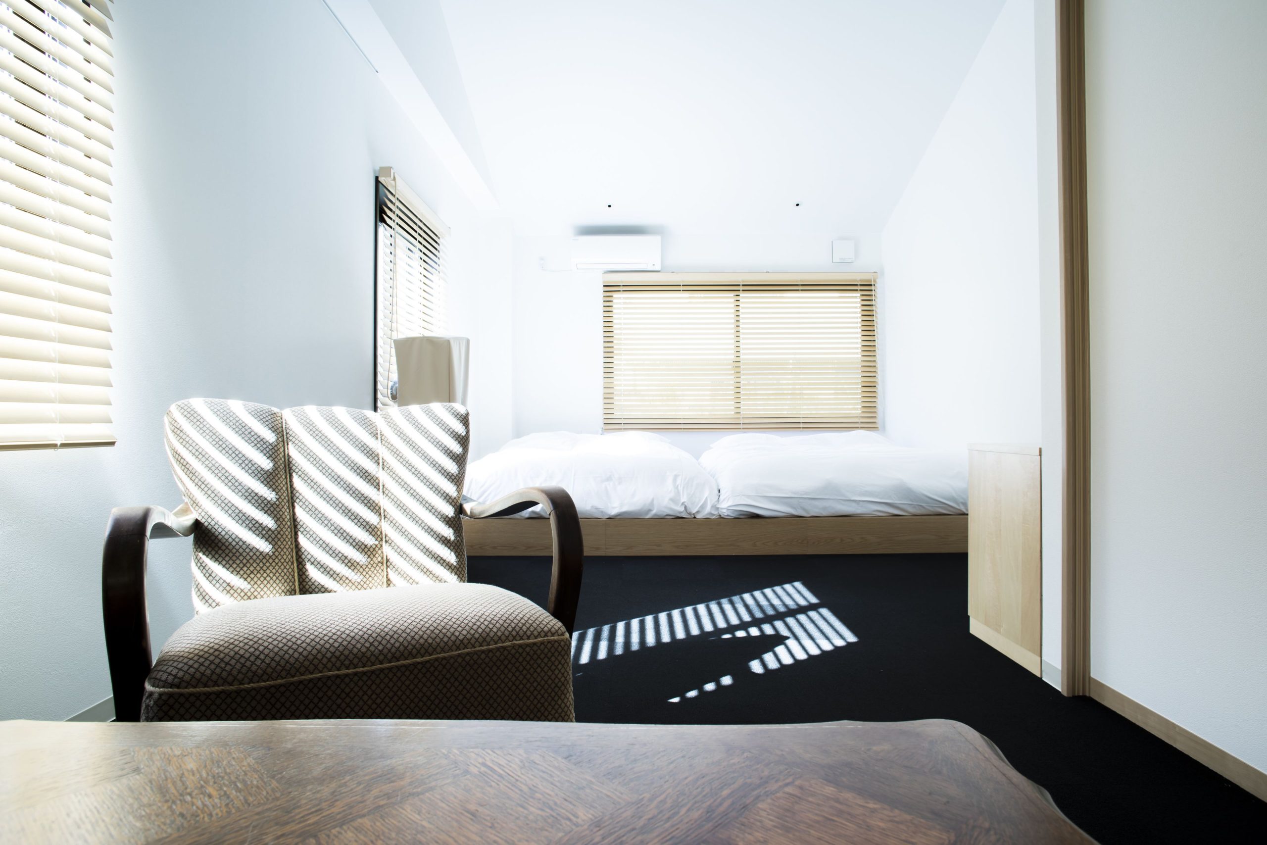 A bright, minimalist twin room at YADO Arashiyama with modern Japanese design—perfect for a peaceful overnight stay during your Arashiyama itinerary.