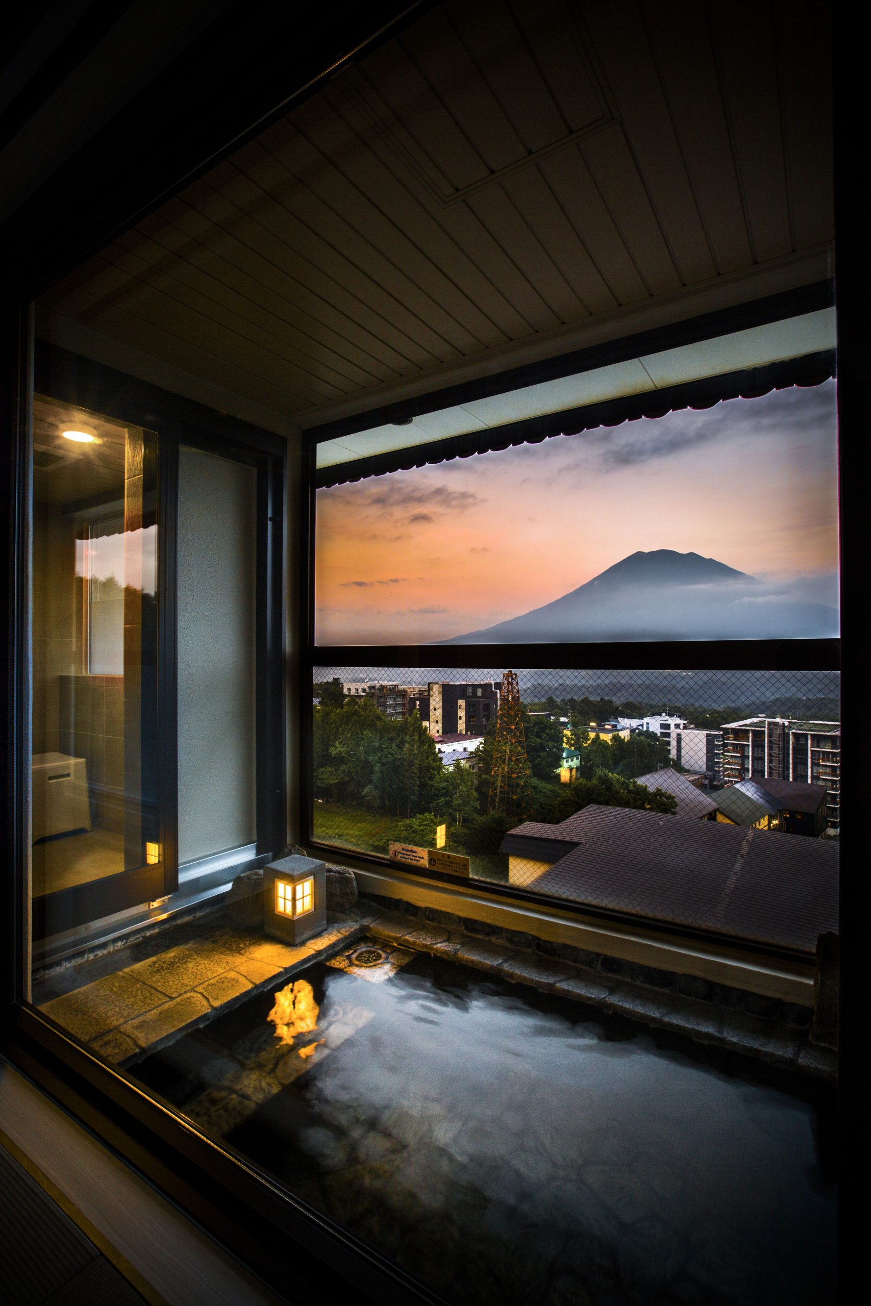Private onsen bath at Yumoto Niseko Prince Hotel Hirafutei with sunset views of Mount Yotei, a relaxing highlight of a Hokkaido winter itinerary.