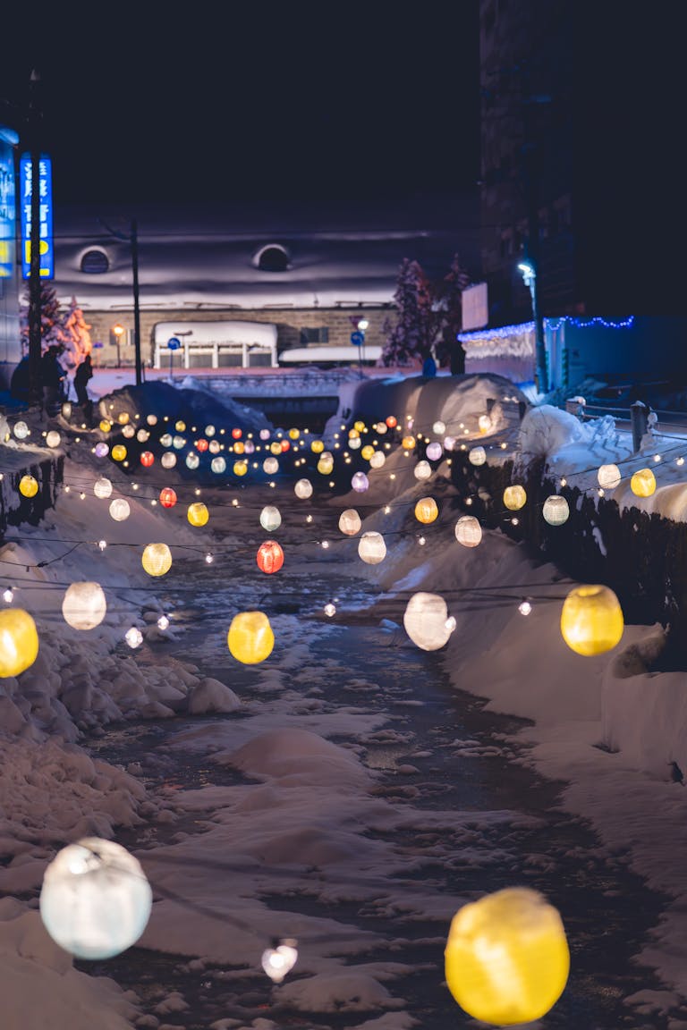 Enchanting street in Otaru, Japan, adorned with glowing lanterns and snowy ambiance.