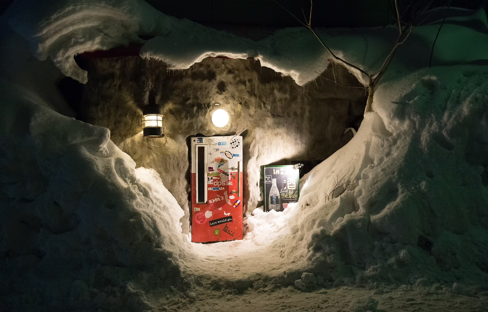 Hidden entrance to Bar Gyu+ through a vintage fridge door in Niseko, a cozy must-visit bar featured in a Hokkaido winter itinerary.