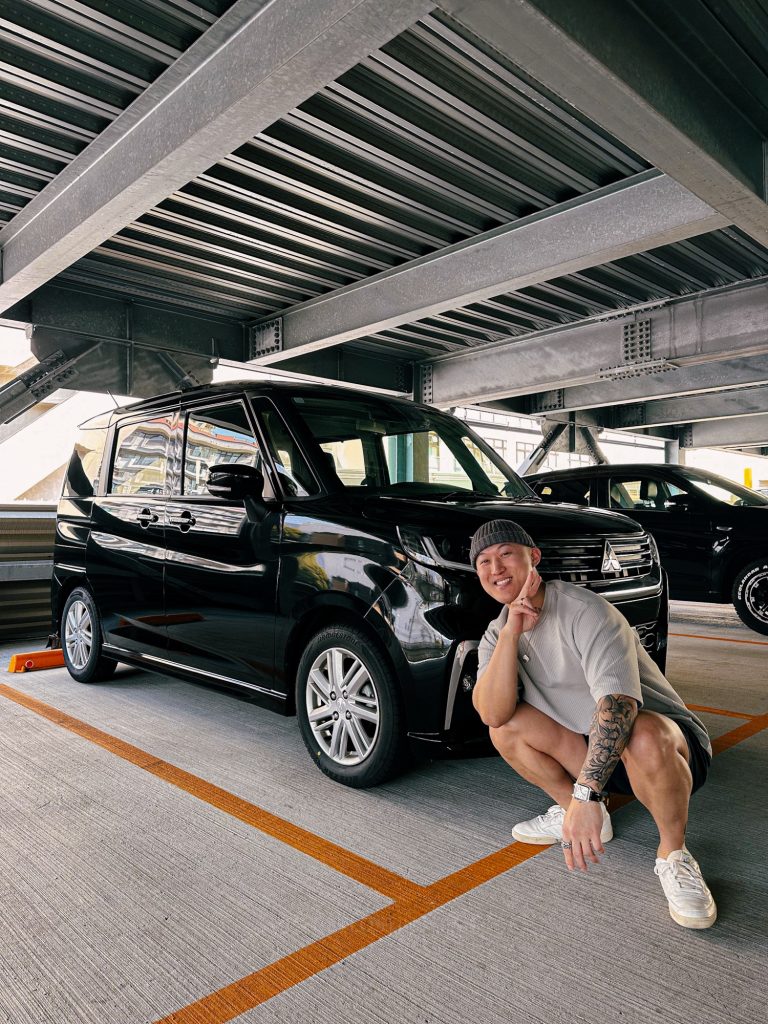 Dennis posing with a rental car in Japan, a flexible way to explore Kyoto and plan your own Arashiyama itinerary.