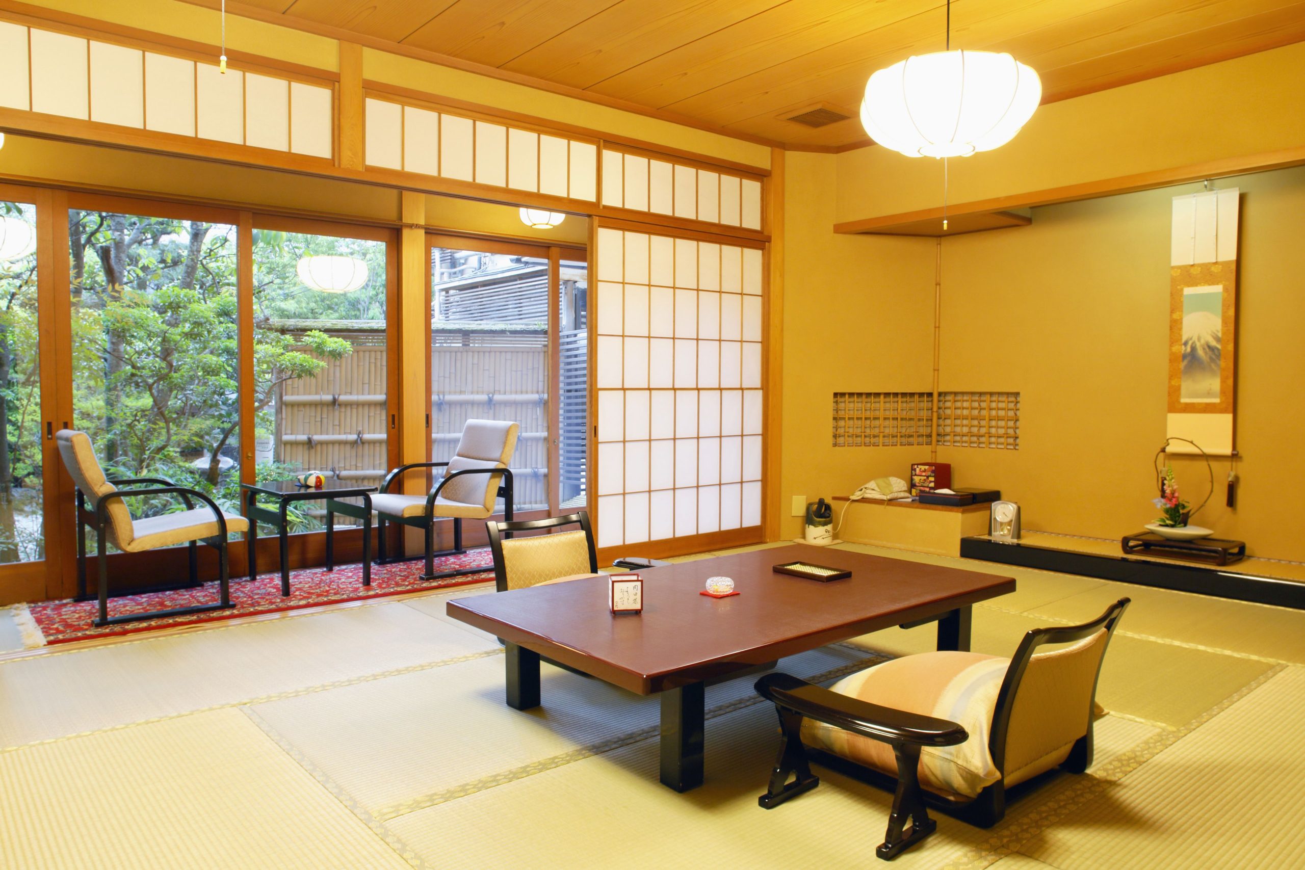 Spacious tatami room at Arashiyama Benkei Ryokan, complete with a low table, shoji screens, and garden-facing seating area at a Kyoto ryokan.