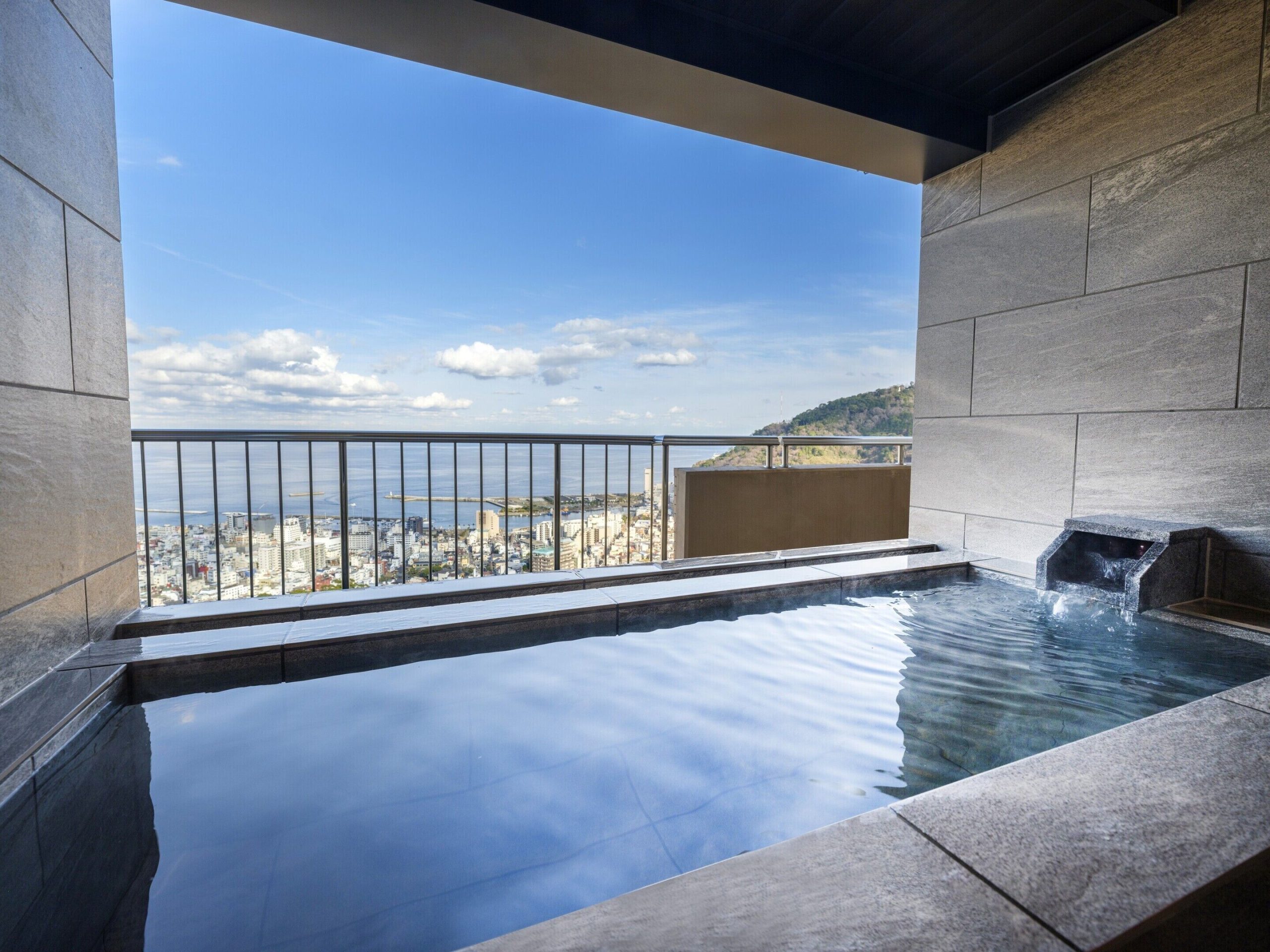 Private onsen bath with ocean views at Kamenoi Hotel Atami, an Atami hotel with private onsen facilities.