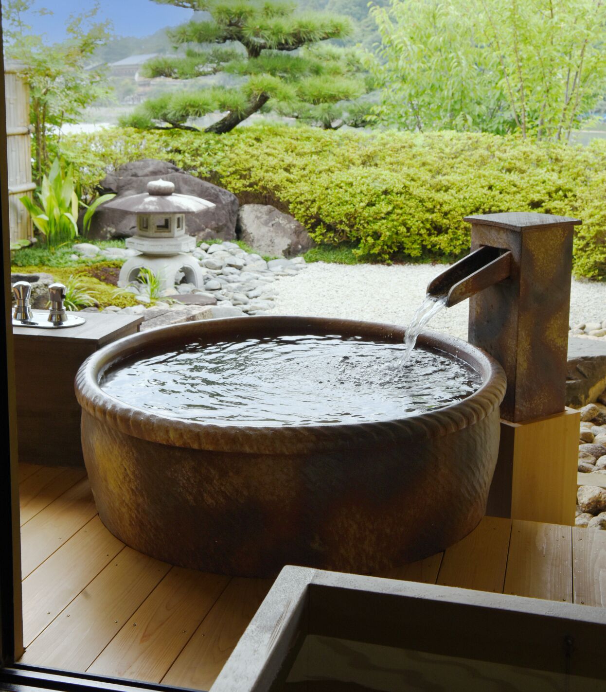 Round stone open-air bath overlooking a Japanese garden at Ryotei Rangetsu.