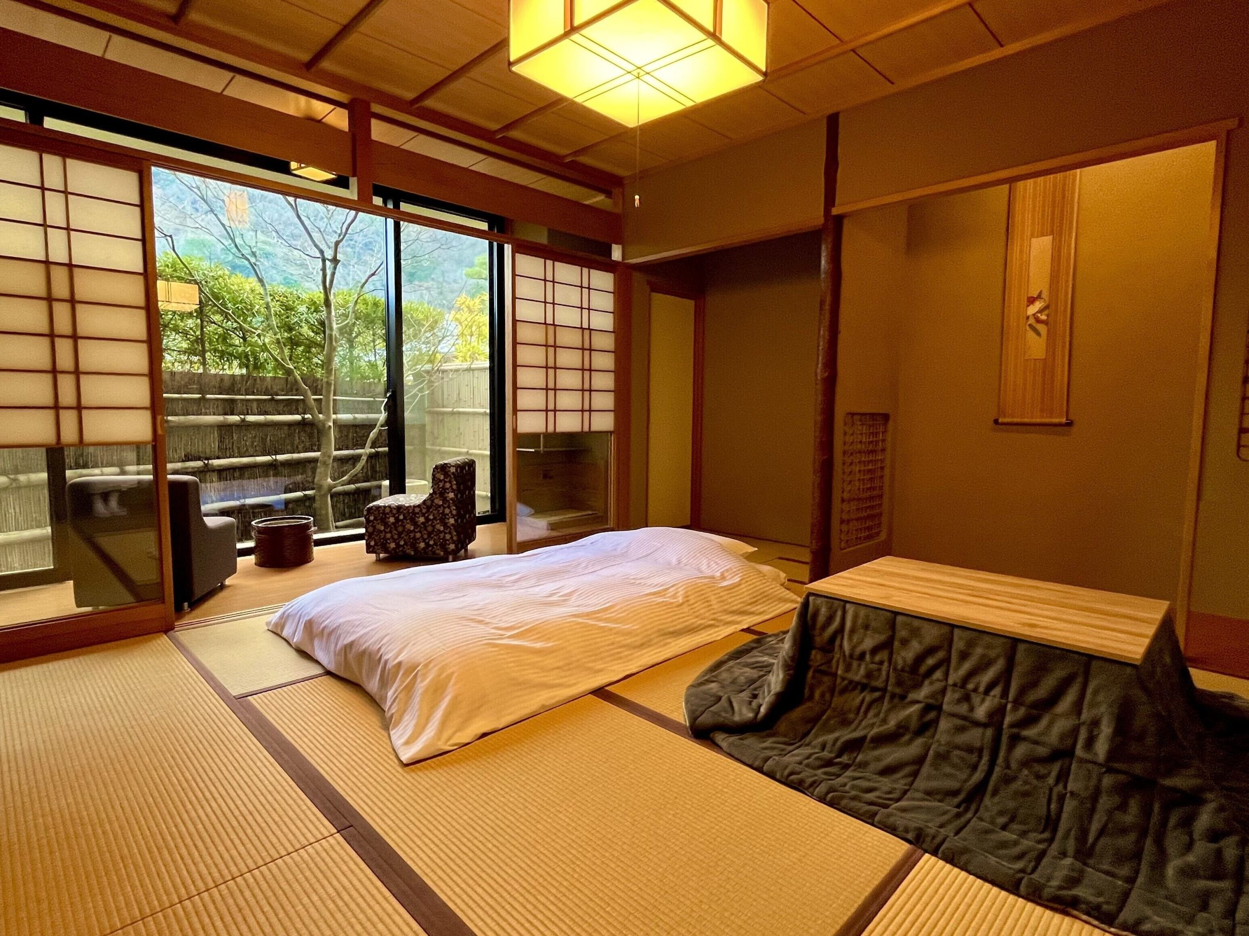 Traditional tatami room with futon bedding and garden views at Ryotei Rangetsu, showcasing the charm of a Kyoto ryokan with private onsen.