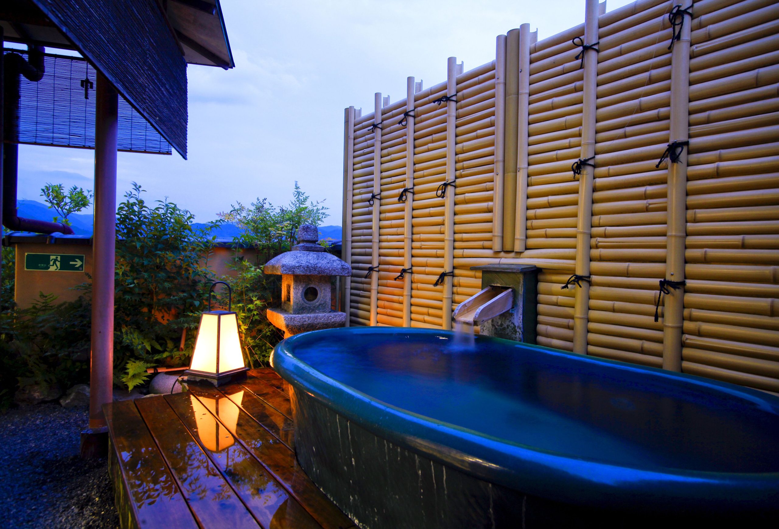 Private ceramic open-air bath at Togetsutei Ryokan, overlooking lush greenery and offering a relaxing soak at a Kyoto ryokan with private onsen.