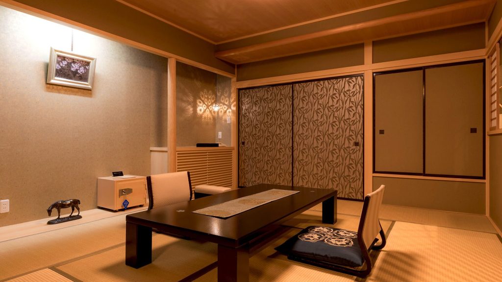 Open-air hot spring bath at Sakuraya, a relaxing Atami ryokan with tranquil evening ambiance and garden scenery.