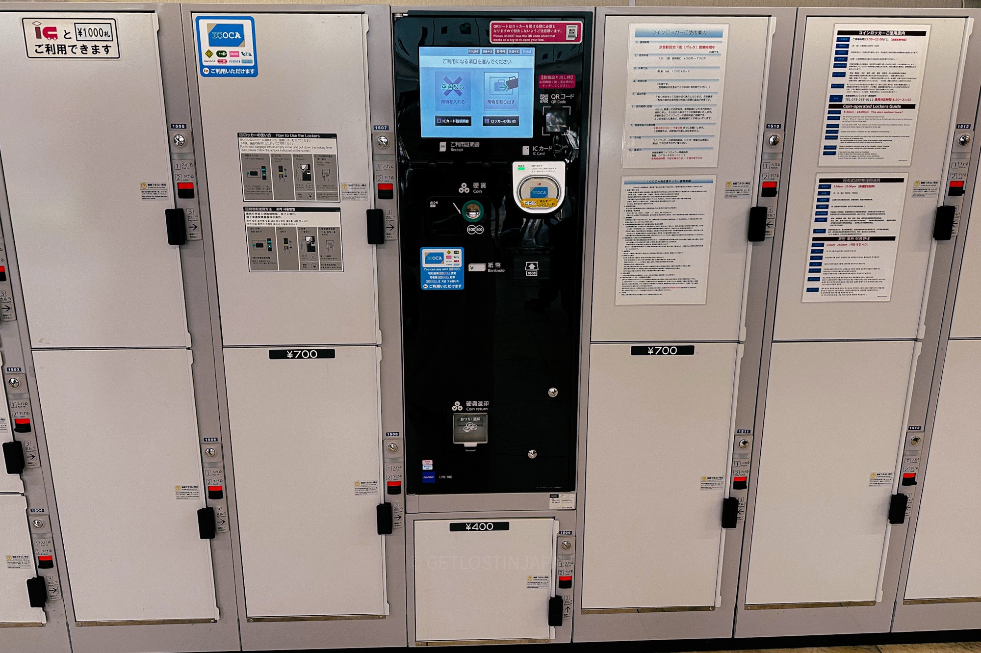 A row of large coin lockers inside a Japanese train station. While these lockers can fit check in luggages, the red symbol indicates they are all occupied.