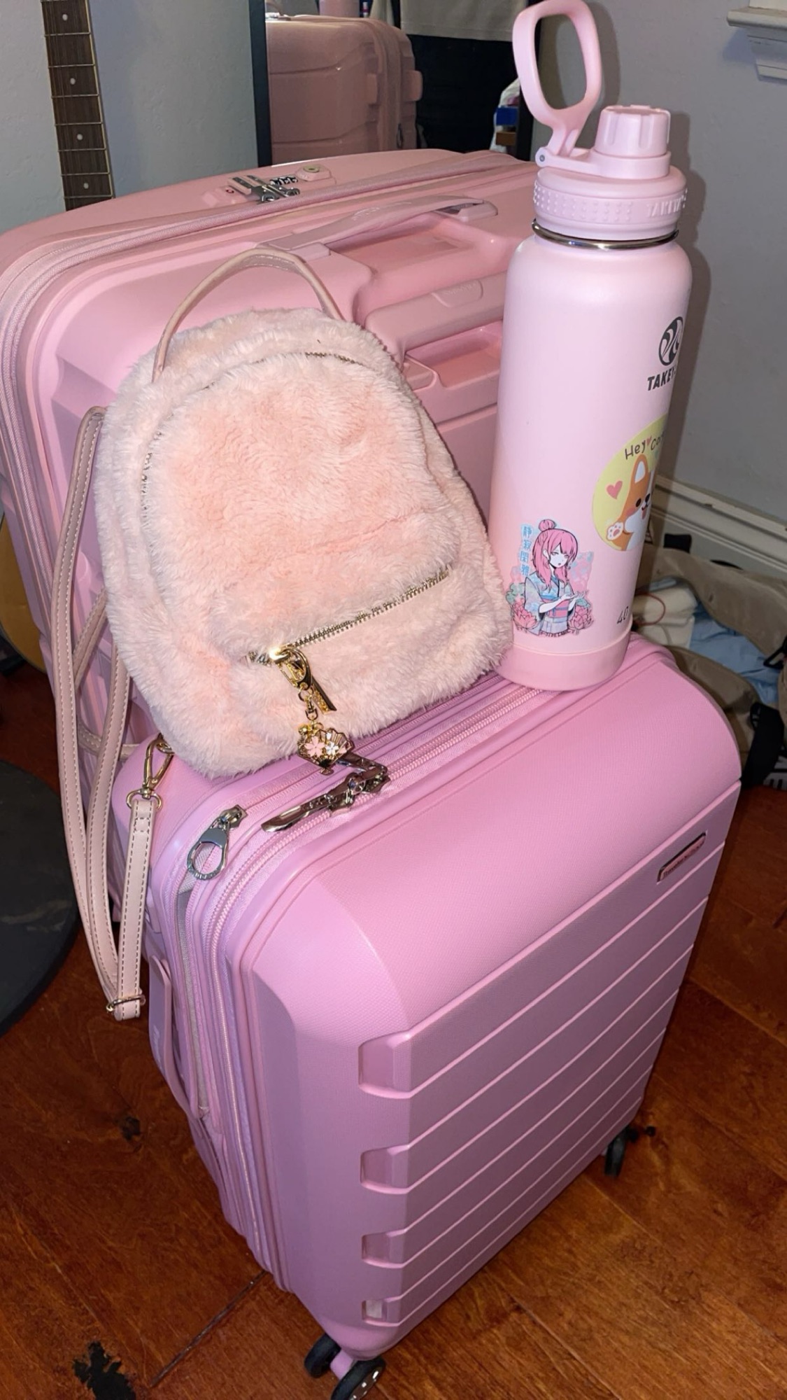 Audrey’s luggage for Japan: A large pink check in suitcase, a carry on suitcase, a small pink backpack, and a light pink water bottle.