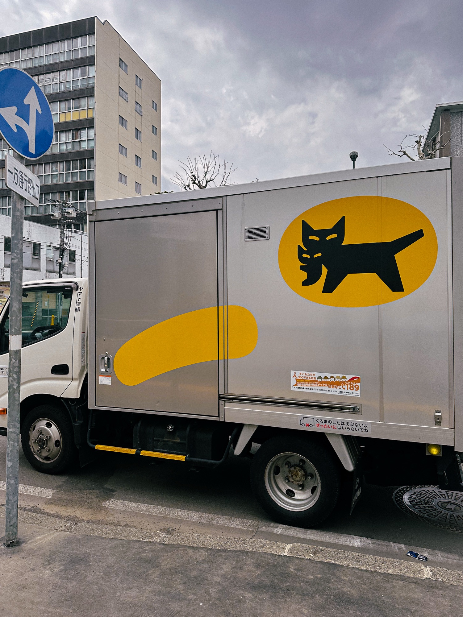A Yamato Transport truck parked on a city street, representing Japan’s overnight luggage delivery service.