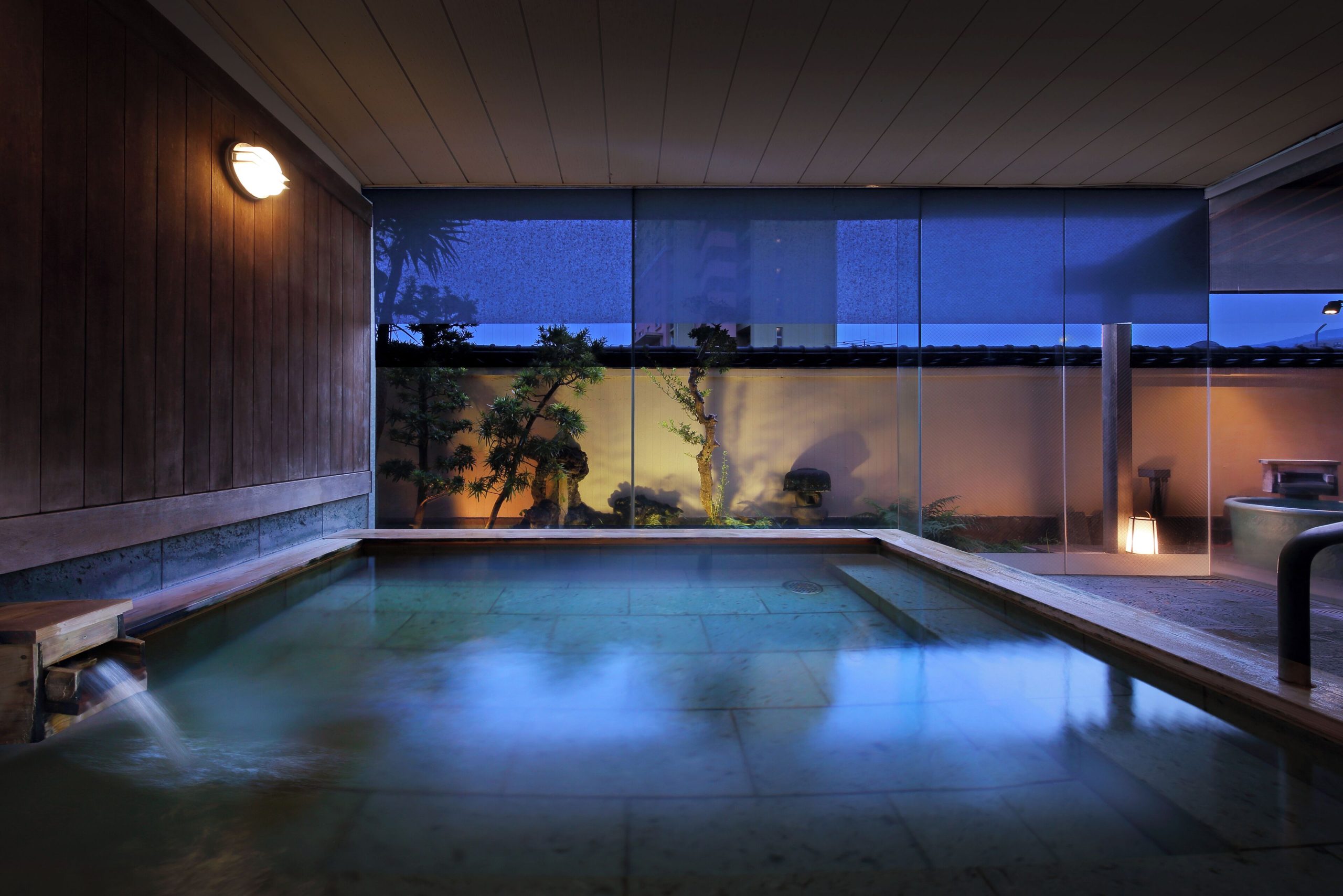Traditional tatami guest room at Sakuraya, an Atami ryokan with low dining table, shoji screens, and soft lighting.