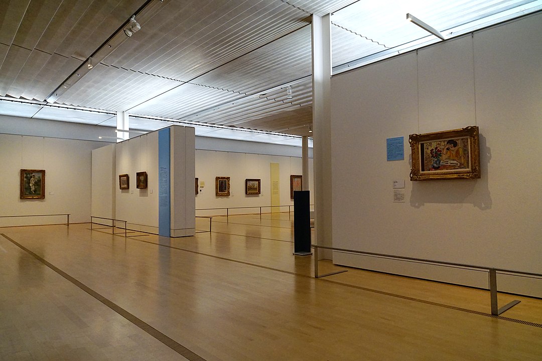 Modern gallery interior of the Pola Museum of Art in Hakone, displaying framed impressionist paintings on minimalist white walls under soft natural lighting.