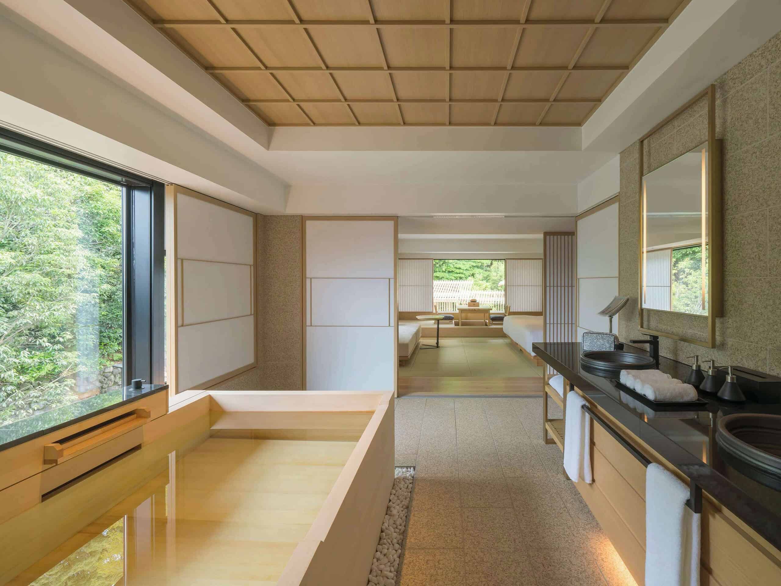 Spacious bathroom at Banyan Tree Higashiyama Kyoto with a hinoki wood soaking tub and garden views, blending luxury with traditional Kyoto aesthetics.