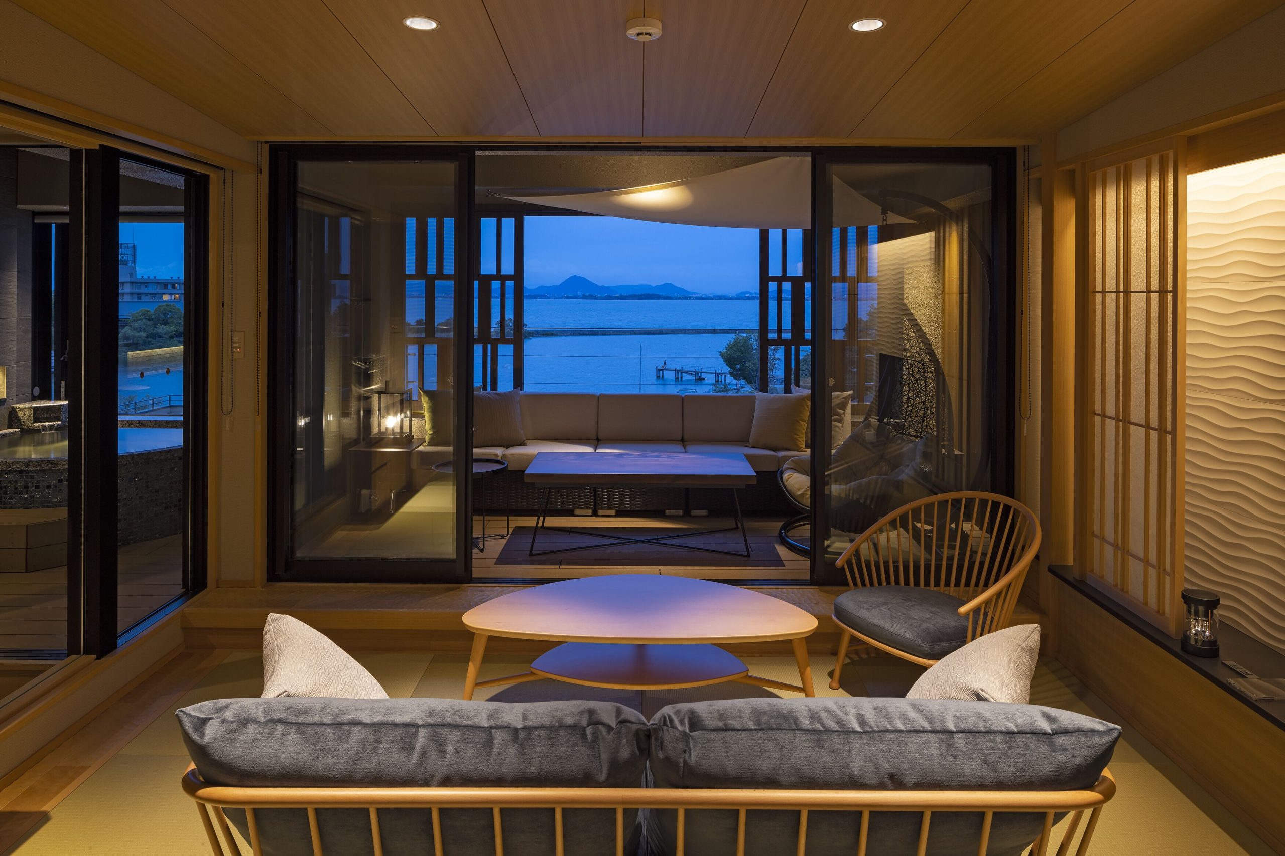 Modern tatami suite at Biwako Ryokusuitei Ryokan featuring lake views, a cozy seating area, and natural wood interiors.