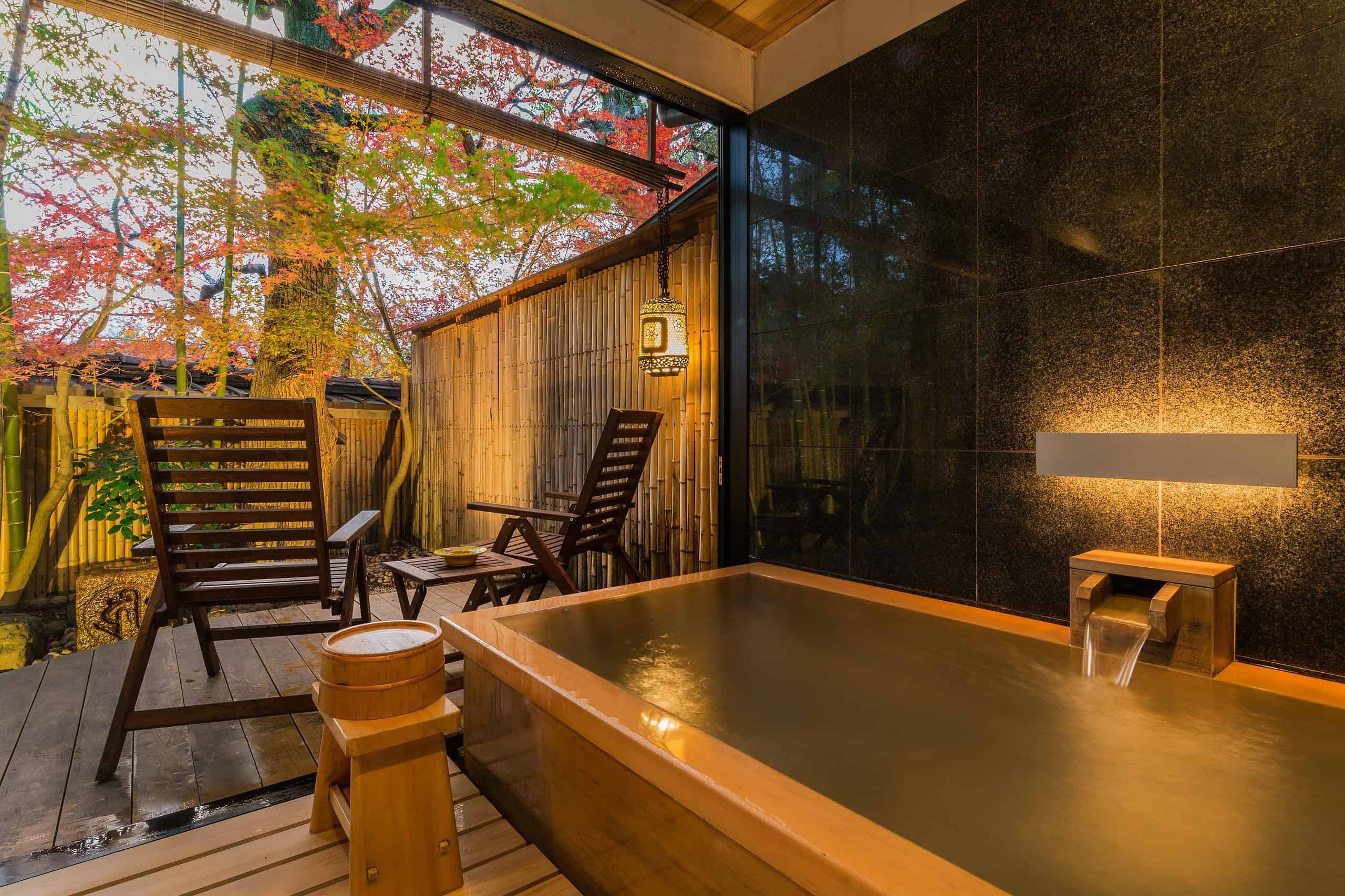 Private open-air bath at Kyoto Nanzenji Garden Ryokan overlooking maple trees and bamboo, offering a tranquil Kyoto forest atmosphere.