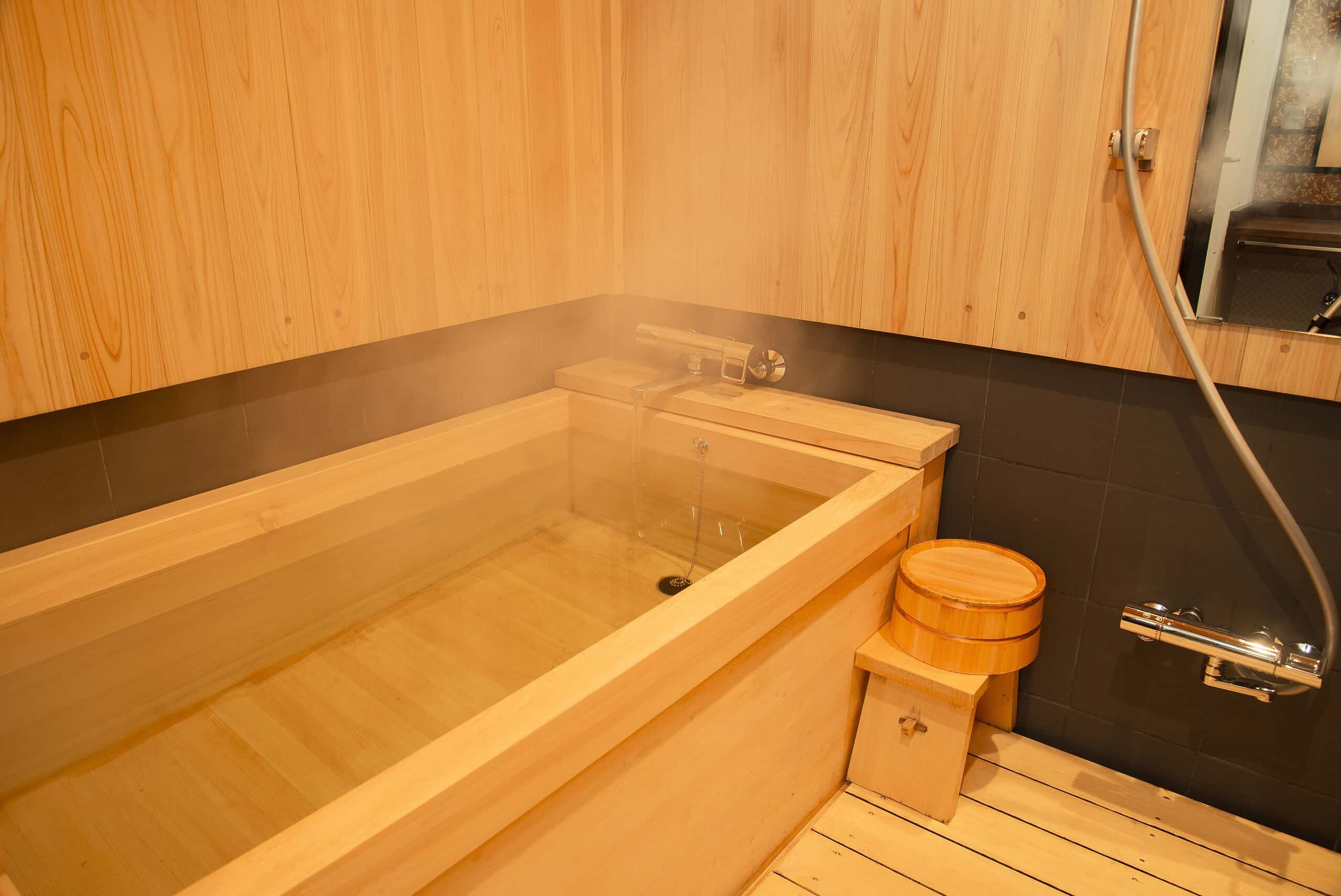 At Kyoto Takasegawa Bettei, the soothing hinoki wood bath provides a tranquil retreat with gentle steam and minimalist Japanese design.