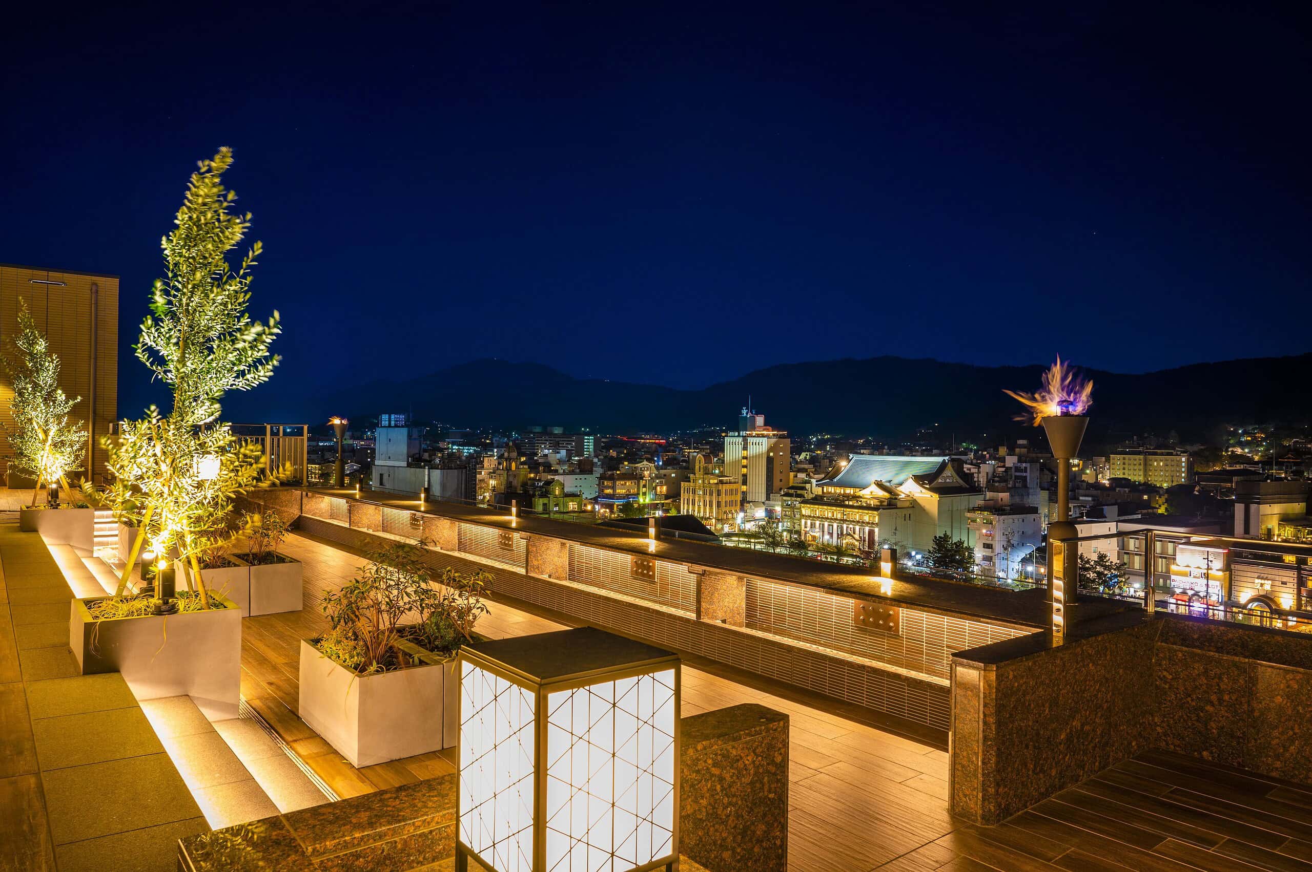 The rooftop terrace at Soraniwa Terrace Kyoto Bettei offers panoramic night views of Kyoto’s skyline, softly illuminated by lanterns and refined architectural lighting.