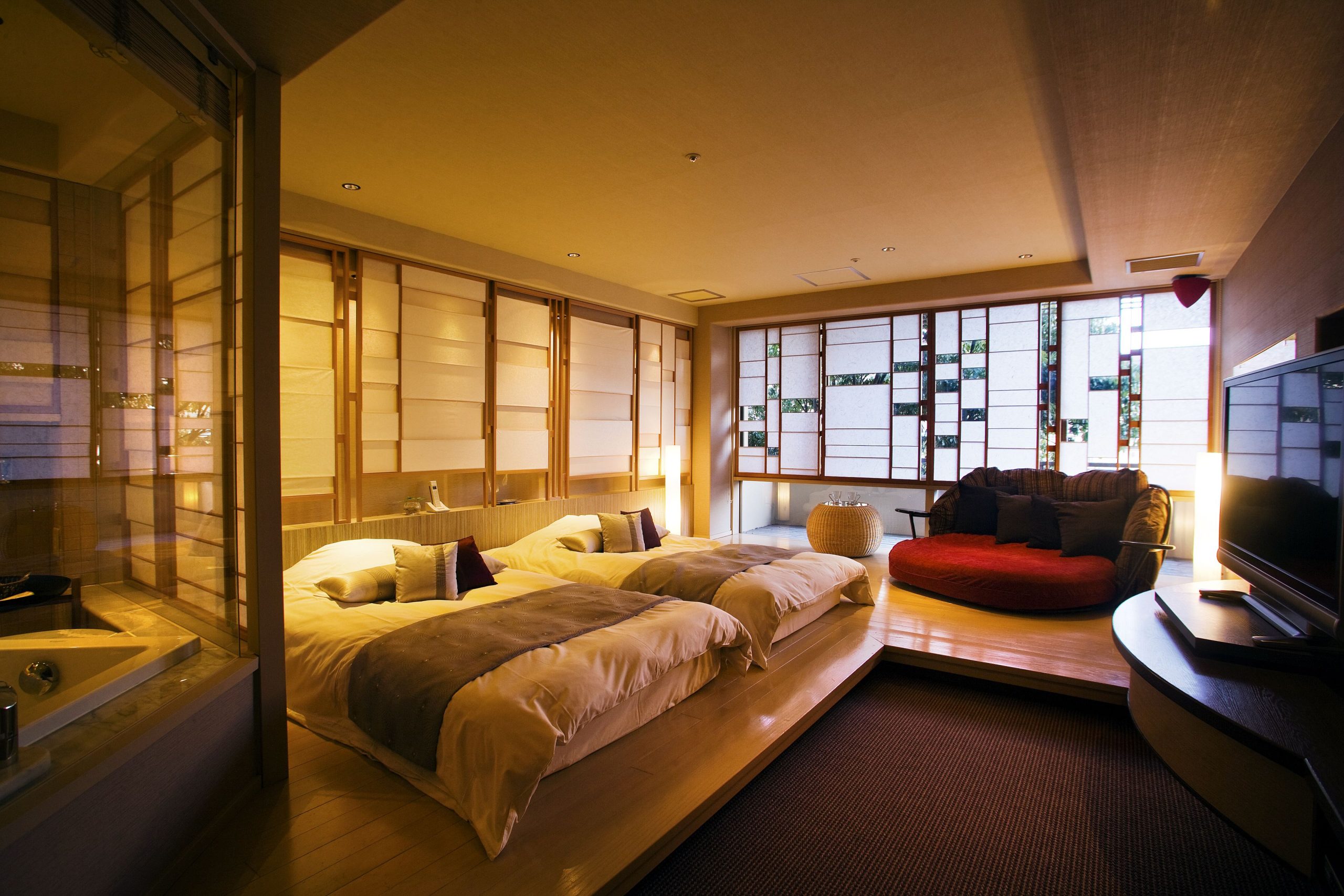 Warm and inviting guest room at Yumotokan Ryokan with soft lighting, twin beds, and shoji screens showcasing Japanese-style elegance.