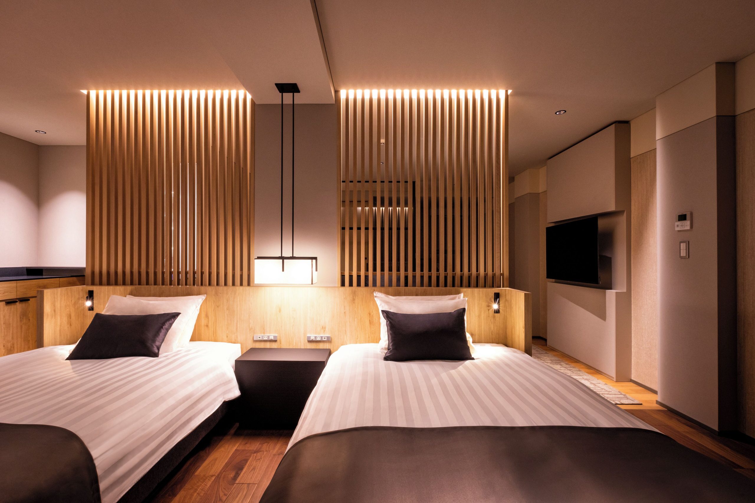 Elegant modern twin room at Lake View Toya Nonokaze Resort featuring warm lighting, wood accents, and a minimalist Japanese-inspired design.